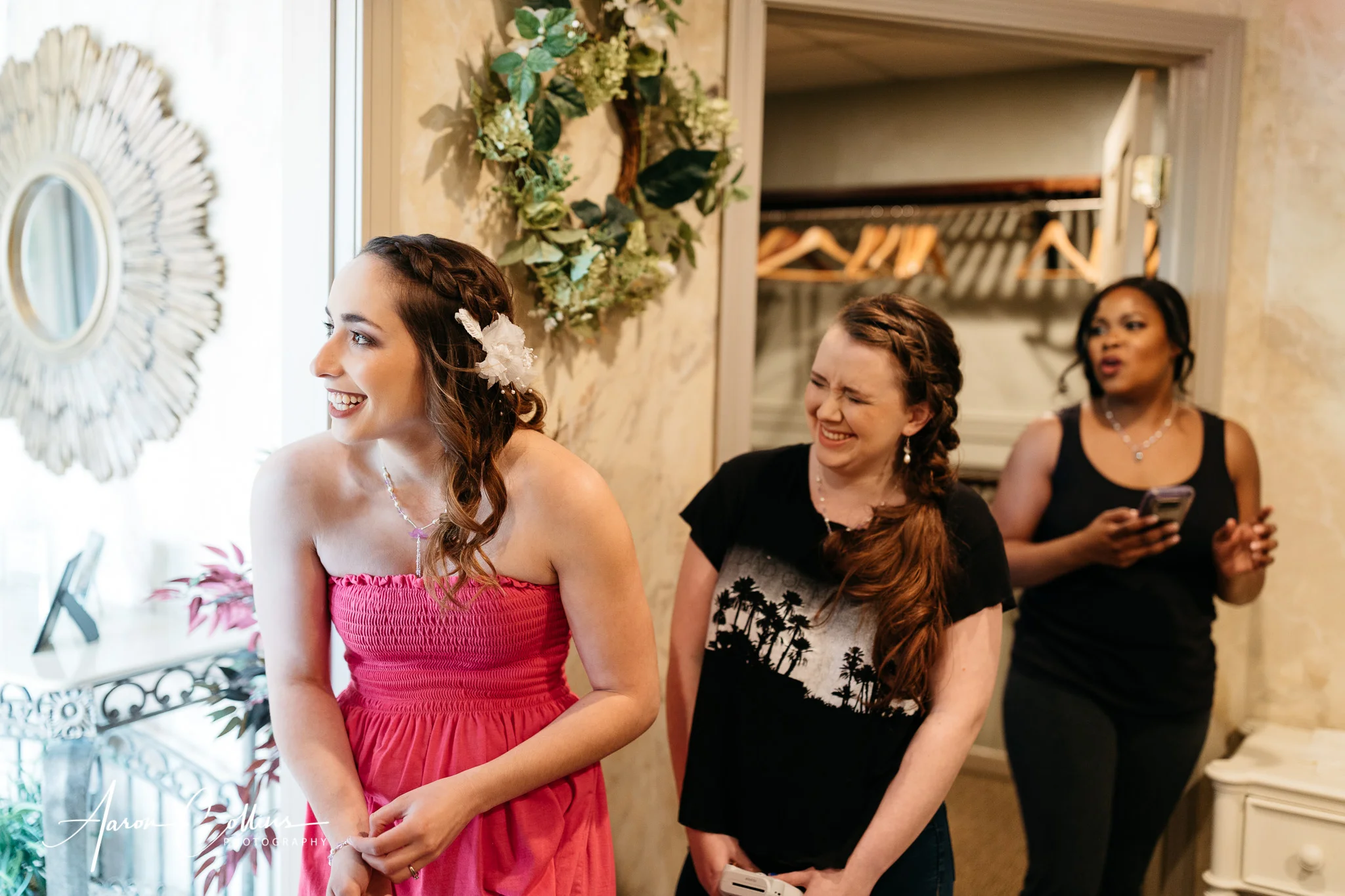 The bride and her entourage of bridesmaids in the bridal room at A Villa Louisa laughing as they wait for a friend to arrive for the wedding.