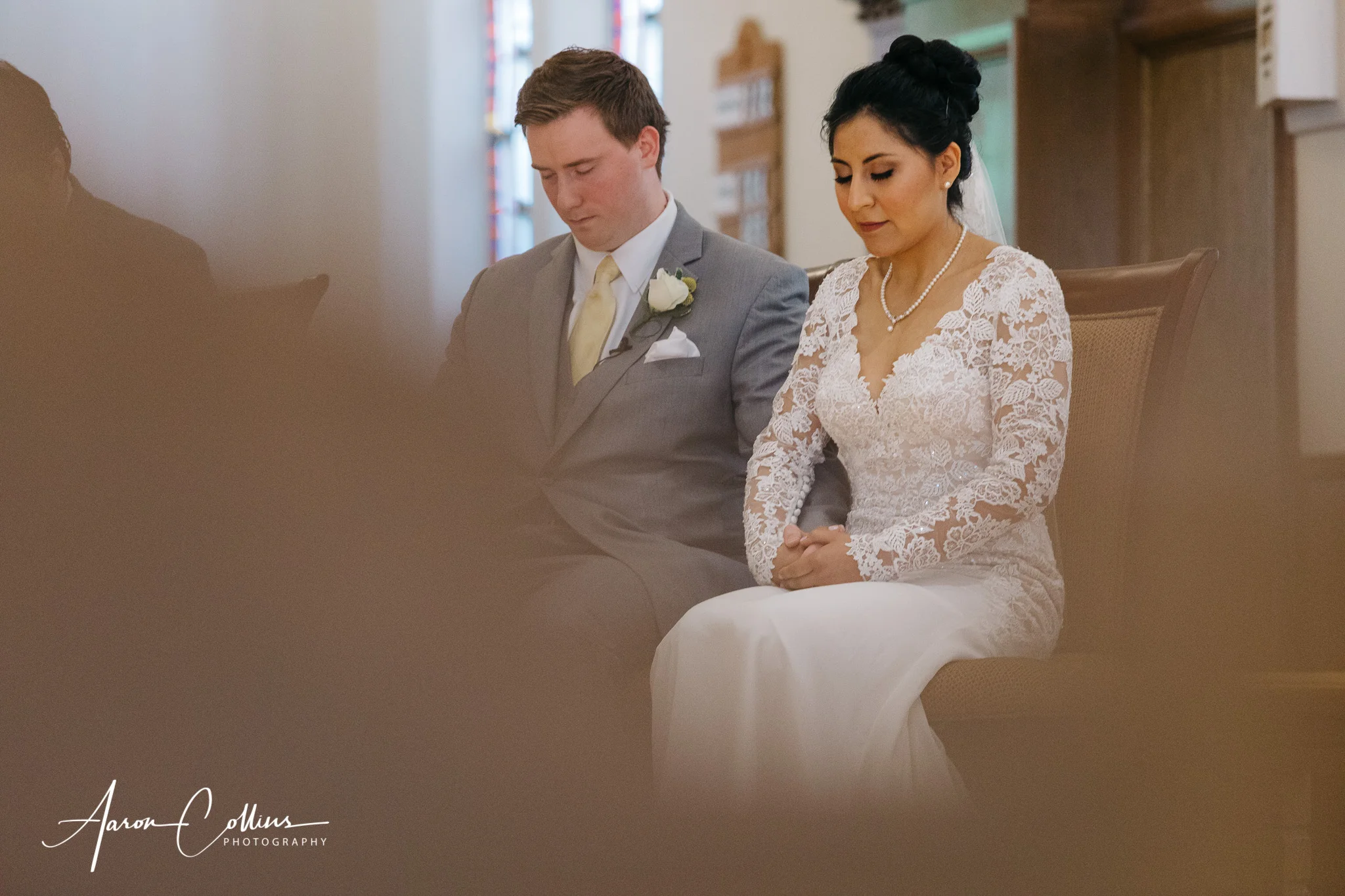 Bride and groom bowing in prayer during their catholic wedding ceremony at Saint George Parish in Worcester MA