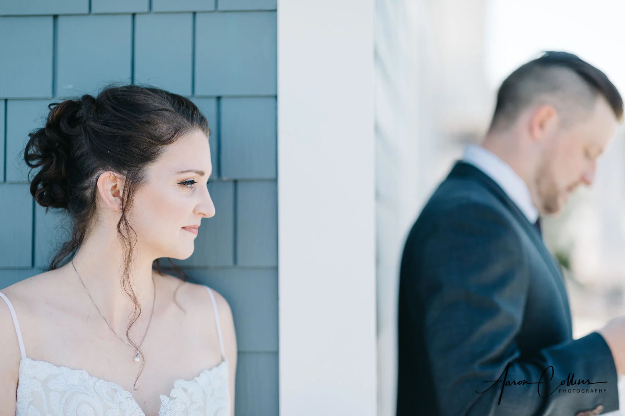 Bride waiting around the corner while her husband to be opens his gifts.