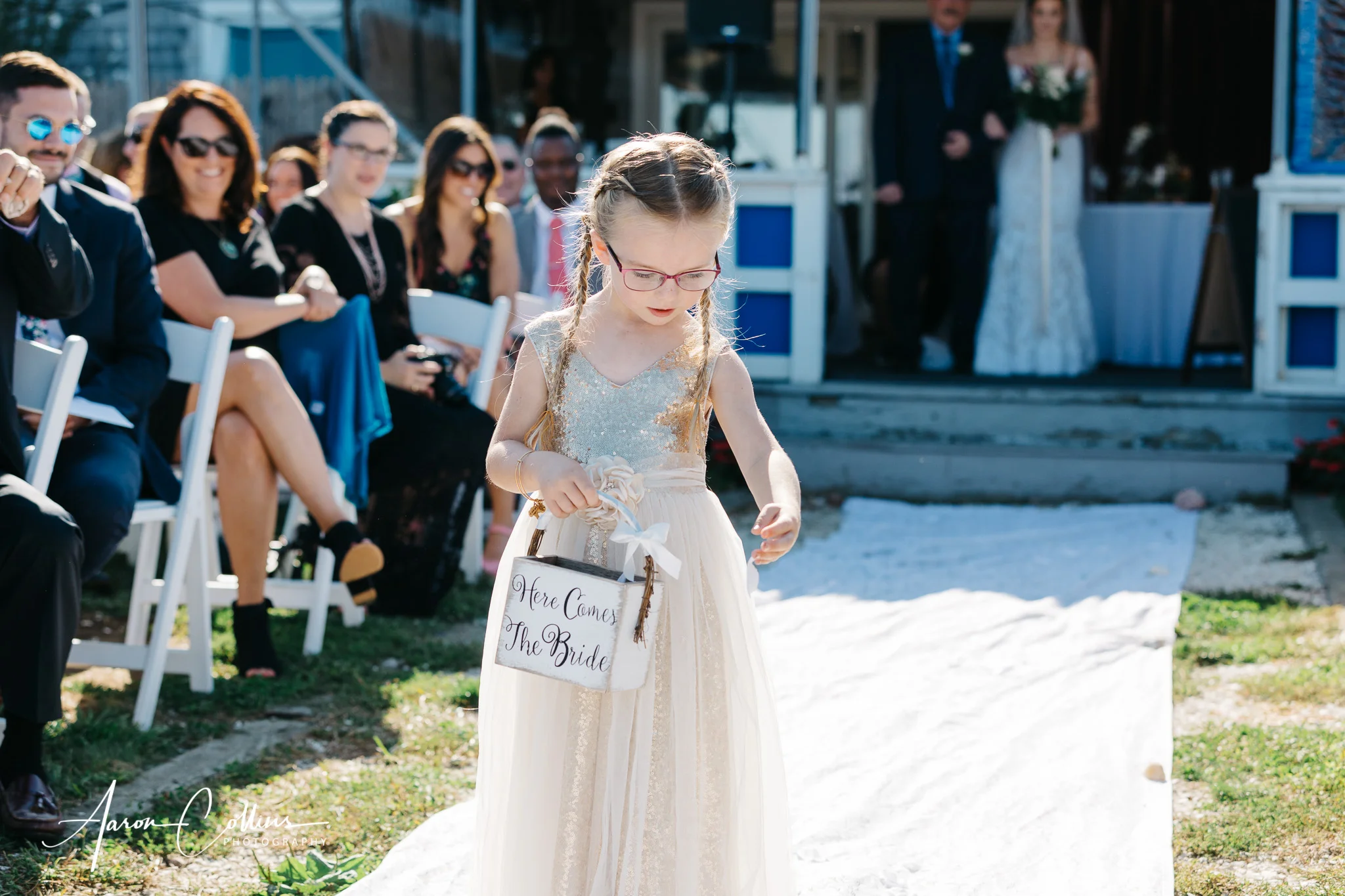 The flower girl drops petals in the aisle.