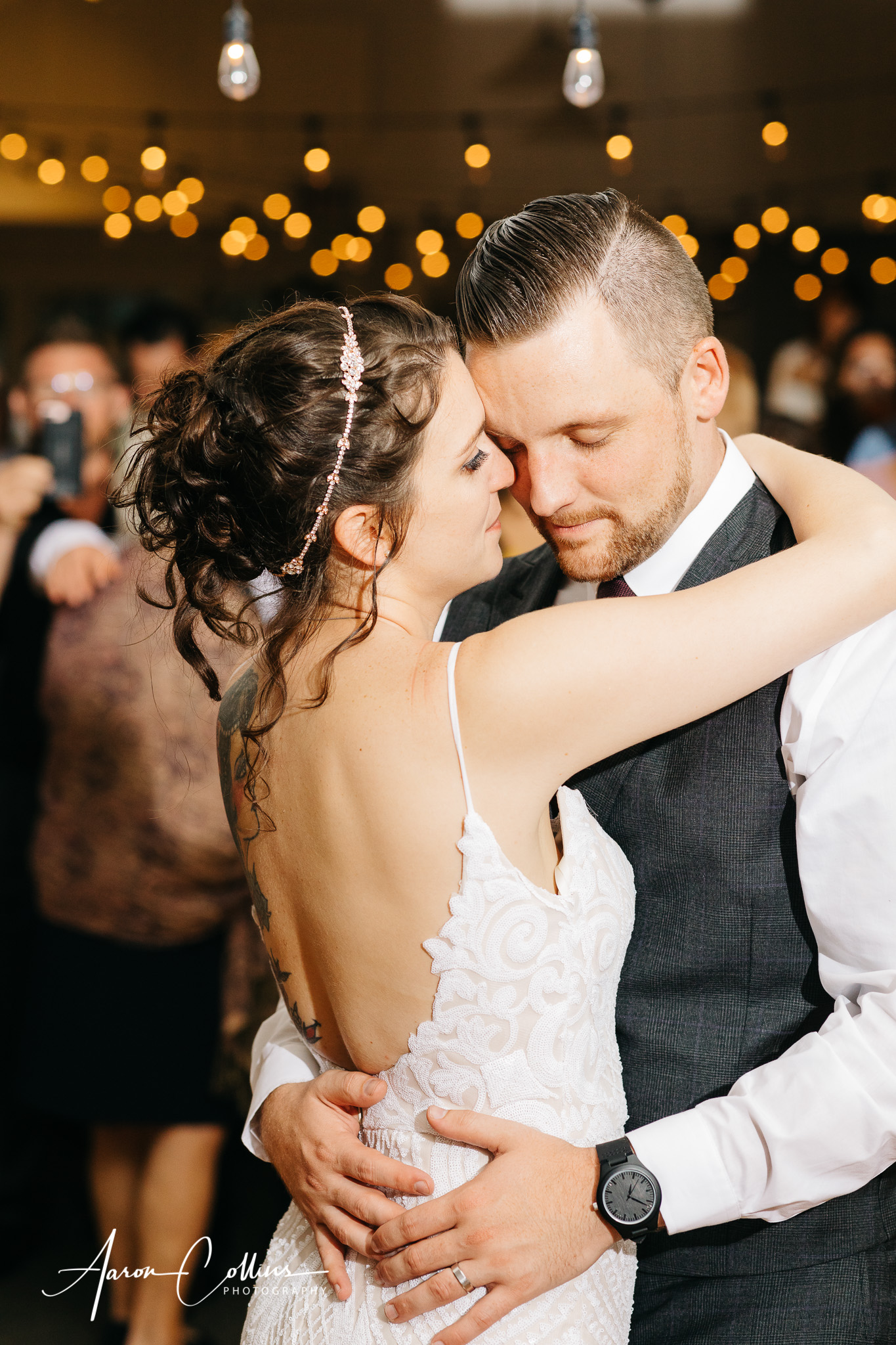 Passionate first dance bride and groom with his hands on her waistat Block Island Maritime Institute with the crowd looking on in the background