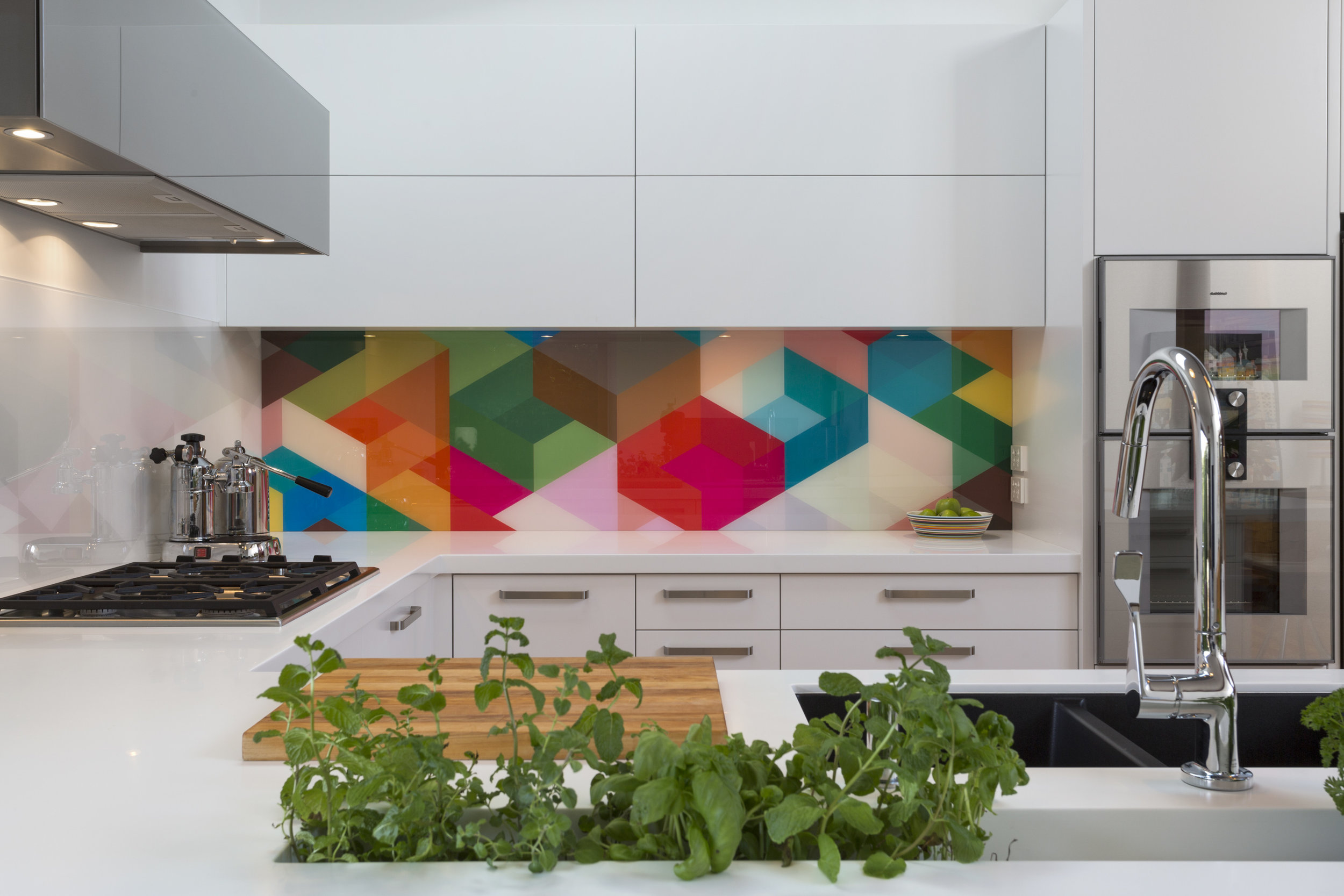 Glass art 3D geometric multi coloured triangles in modern white kitchen