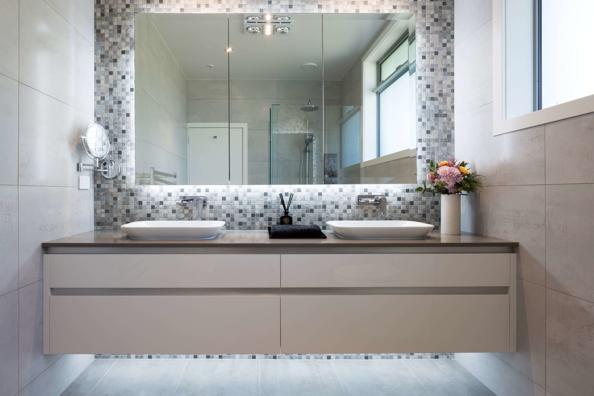 Backlit square bathroom mirrors with bevelled edges in tiled bathroom