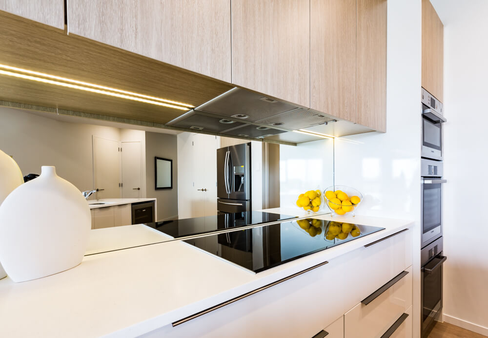 Mirrored glass splashback for apartment kitchen