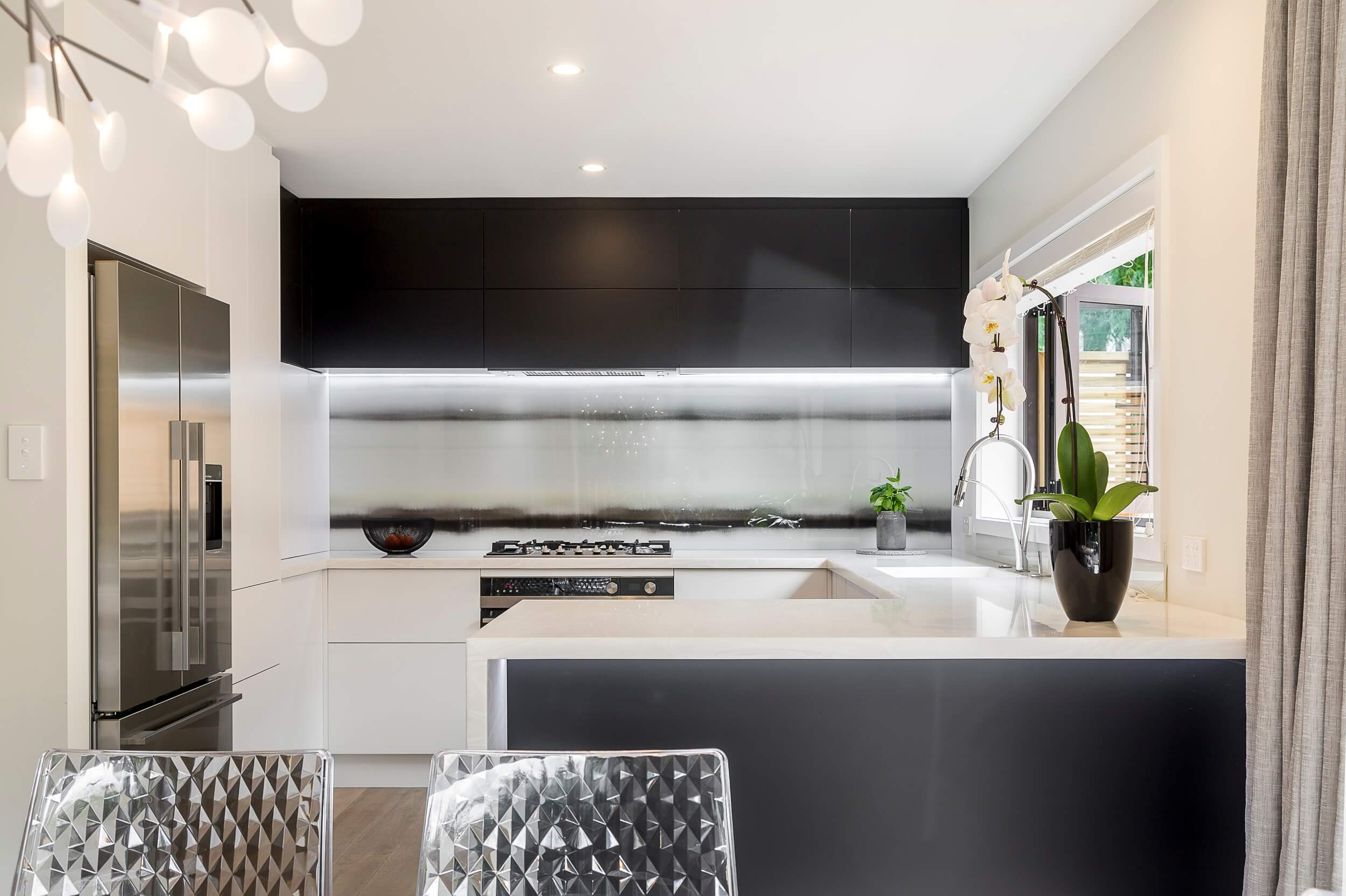 Elegant two tone kitchen with printed glass art splashback