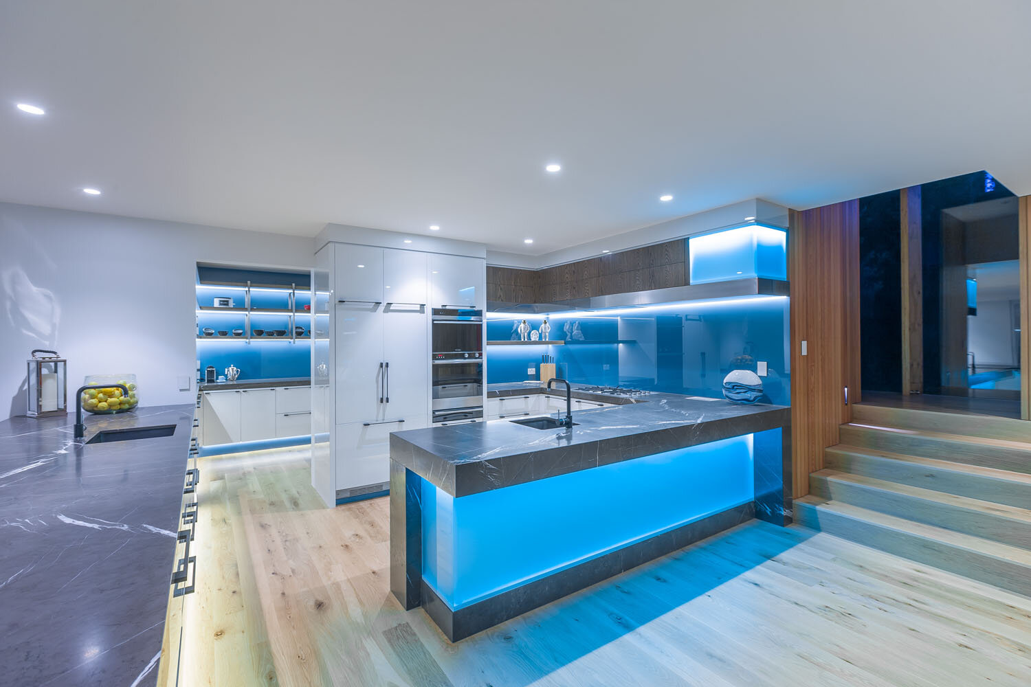 Modern contemporary kitchen and scullery with glass splashback and island back