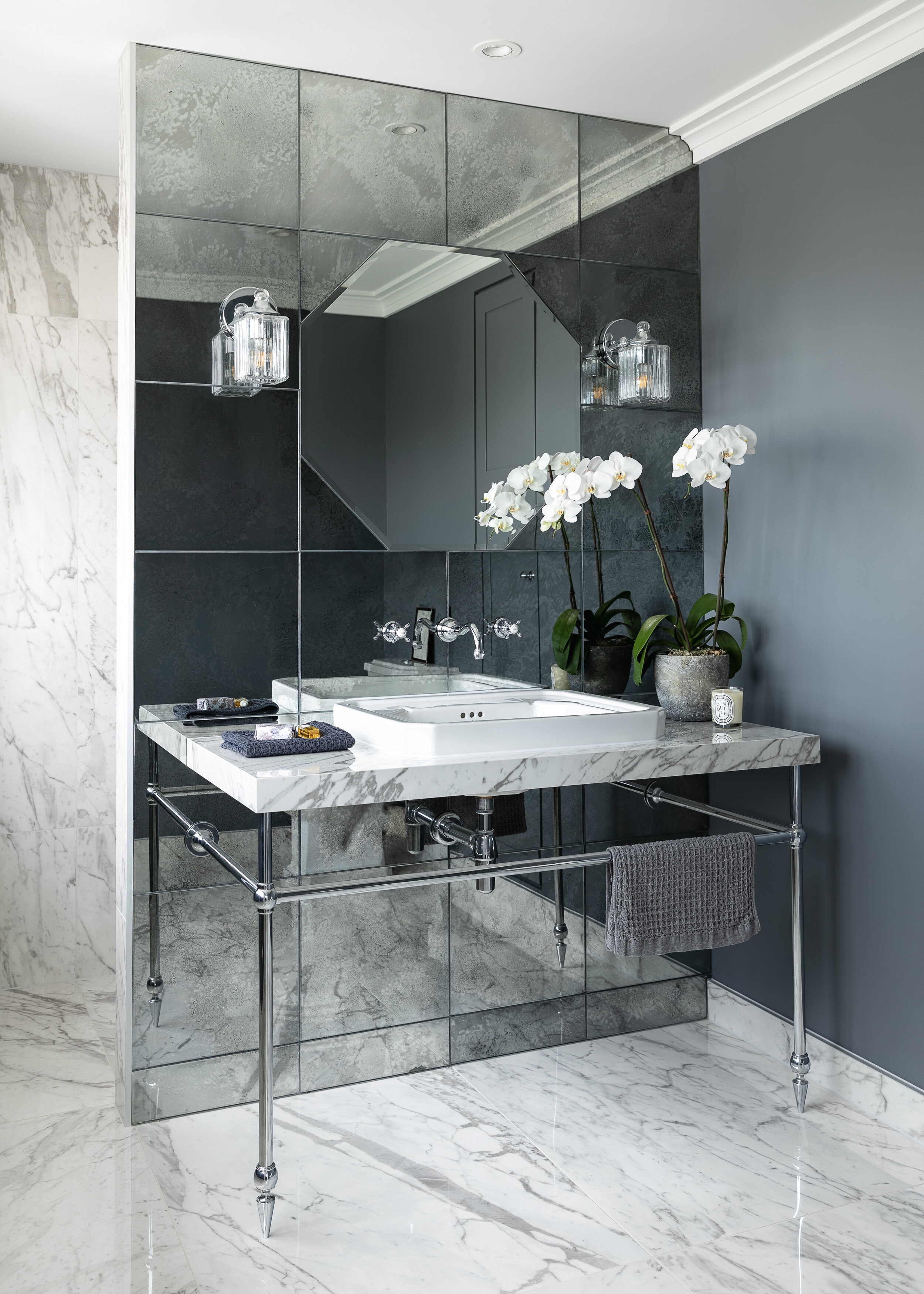 Octagonal shaped mirror inset into antique mirror tiled wall