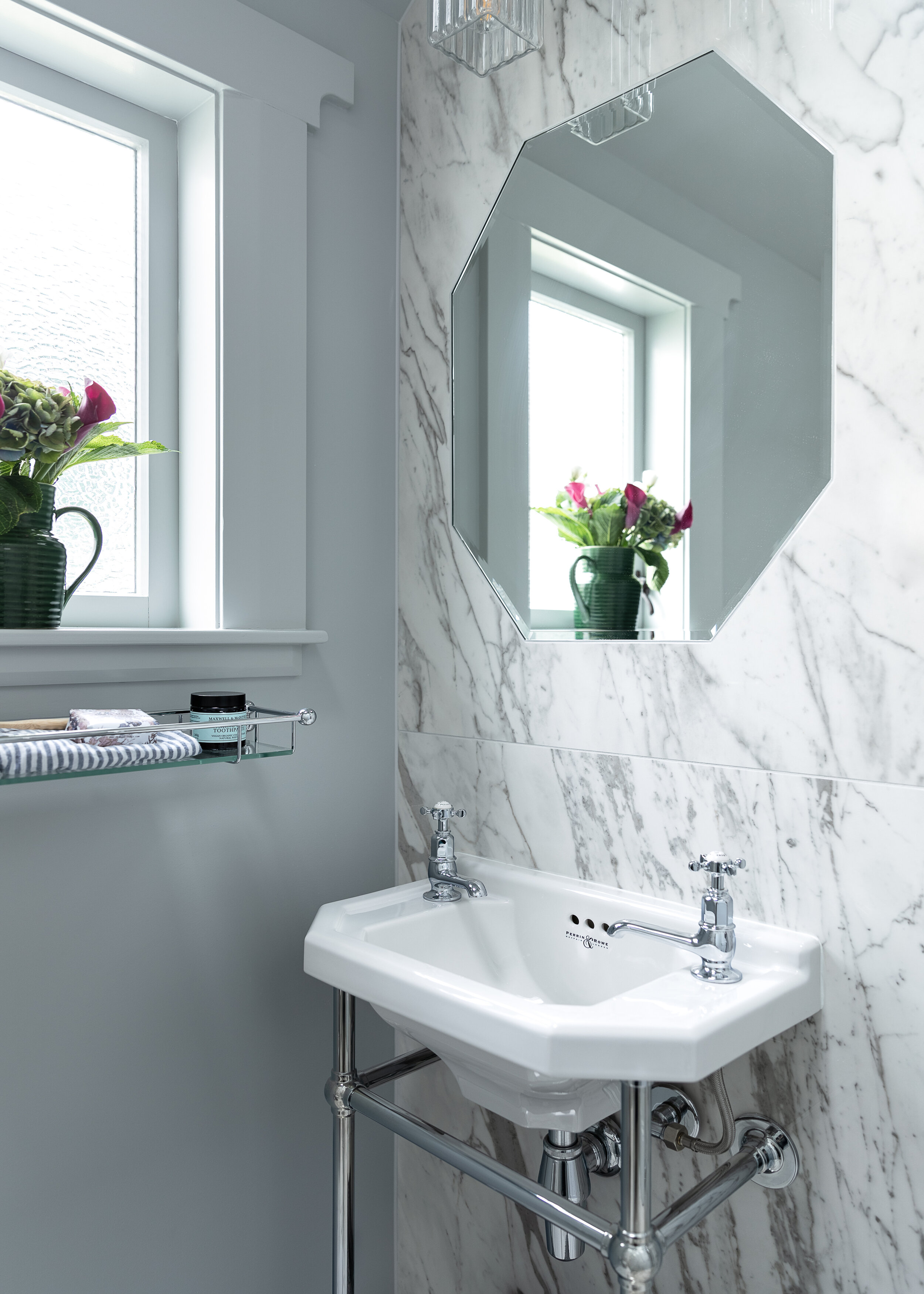 Octagonal shaped mirror inset into marbled bathroom wall