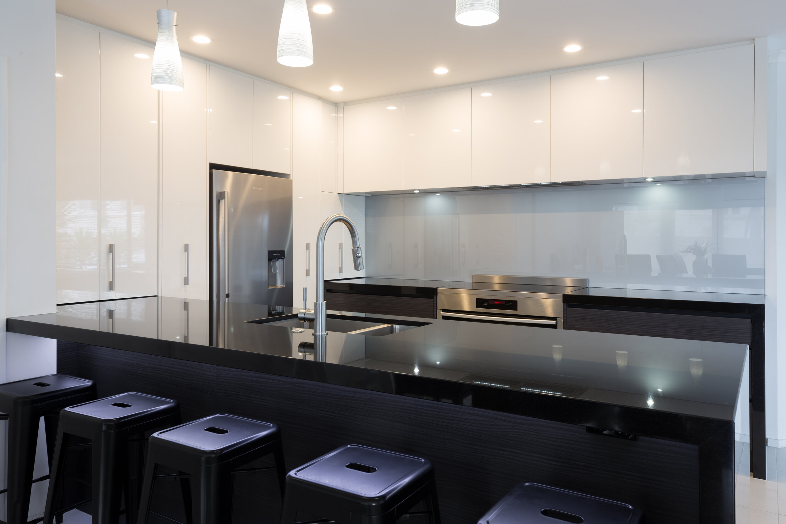 Award winning contemporary kitchen with grey-blue backpainted glass splashback
