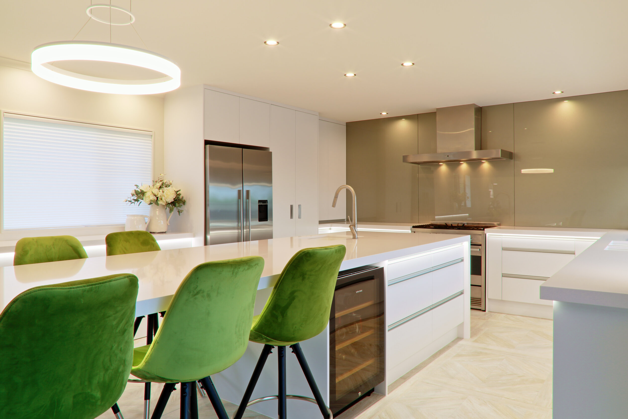 Large contemporary award winning kitchen with full height glass splashback in gold