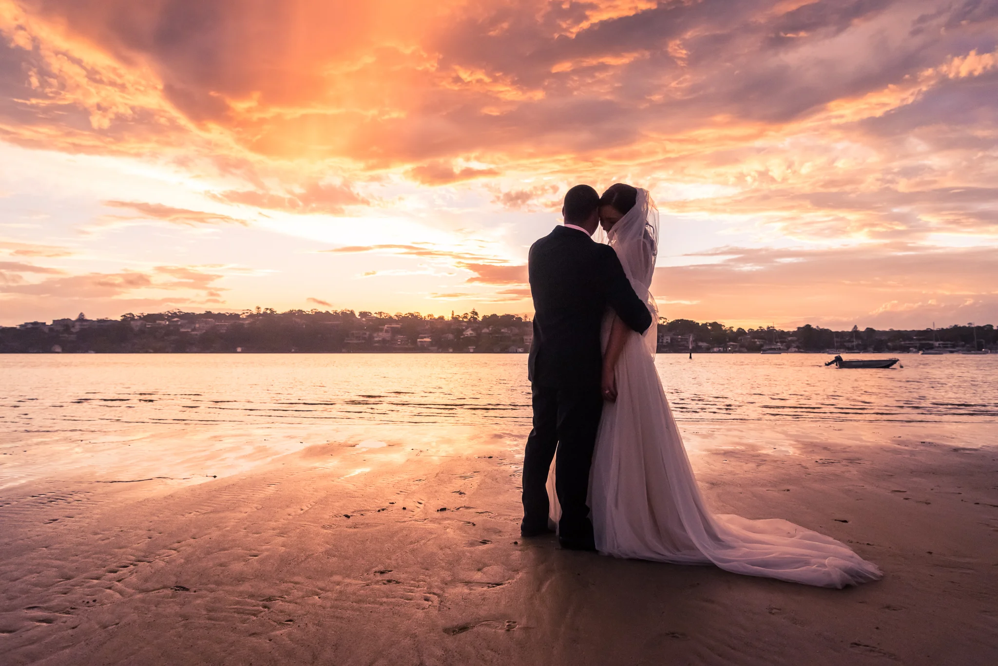 sunset on the beach with bride and groom