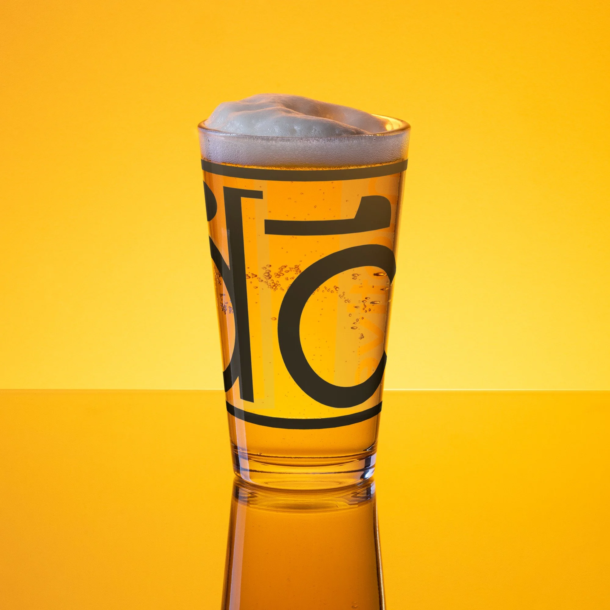 Shaker pint glass with long logo — dc motive