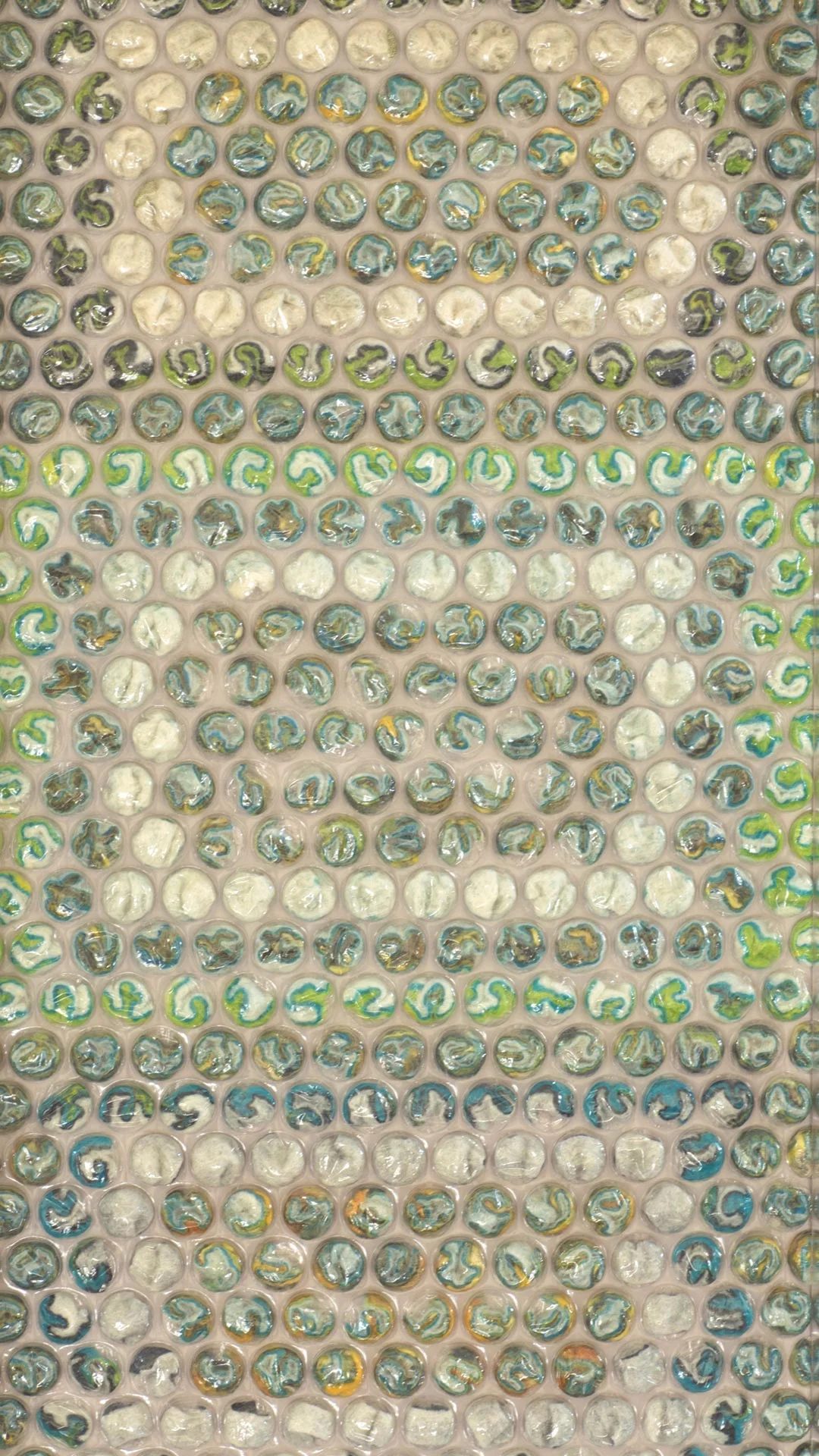 Bubble wrap textile art which features as part of Gail Hawes exhibition ROUND. All artworks featured bubble wrap filled with a variety of textiles including wool, hand made felt, silk fabric. This artwork features multi coloured, layered hand made and hand stitched feltwithin the bubbles.