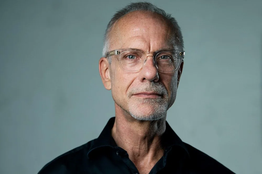 Headshot of male wearing black polo shirt