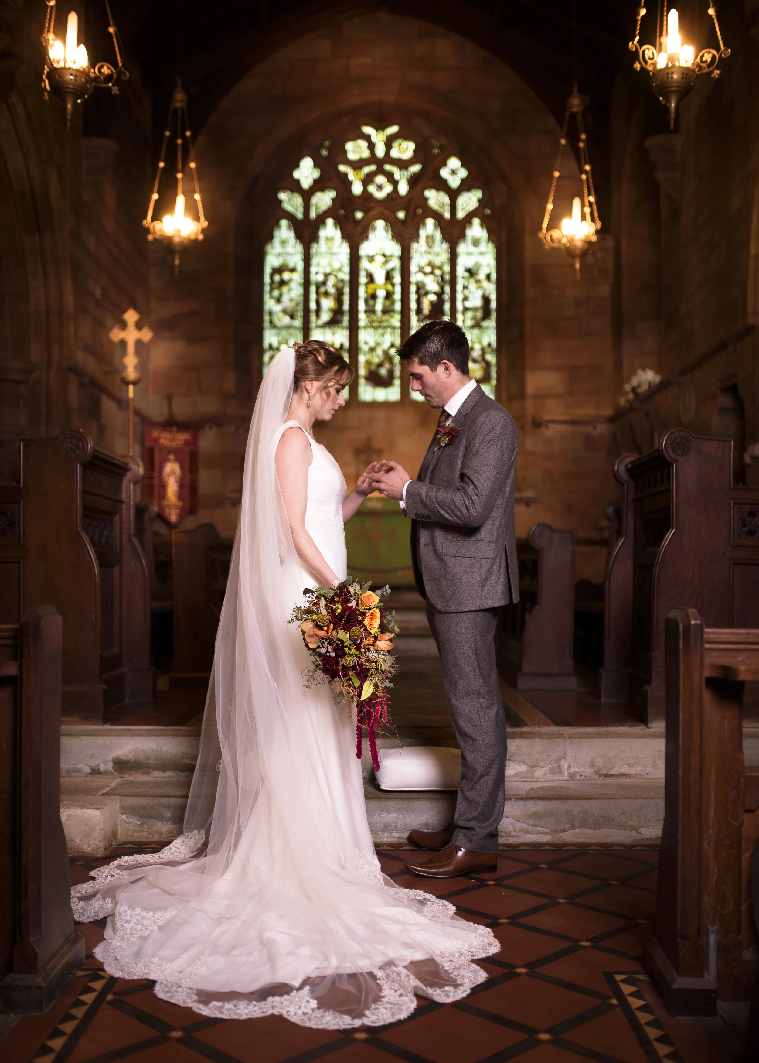 Bride and groom exchanging rings during a church wedding ceremony in Warwickshire, photographed on film.
