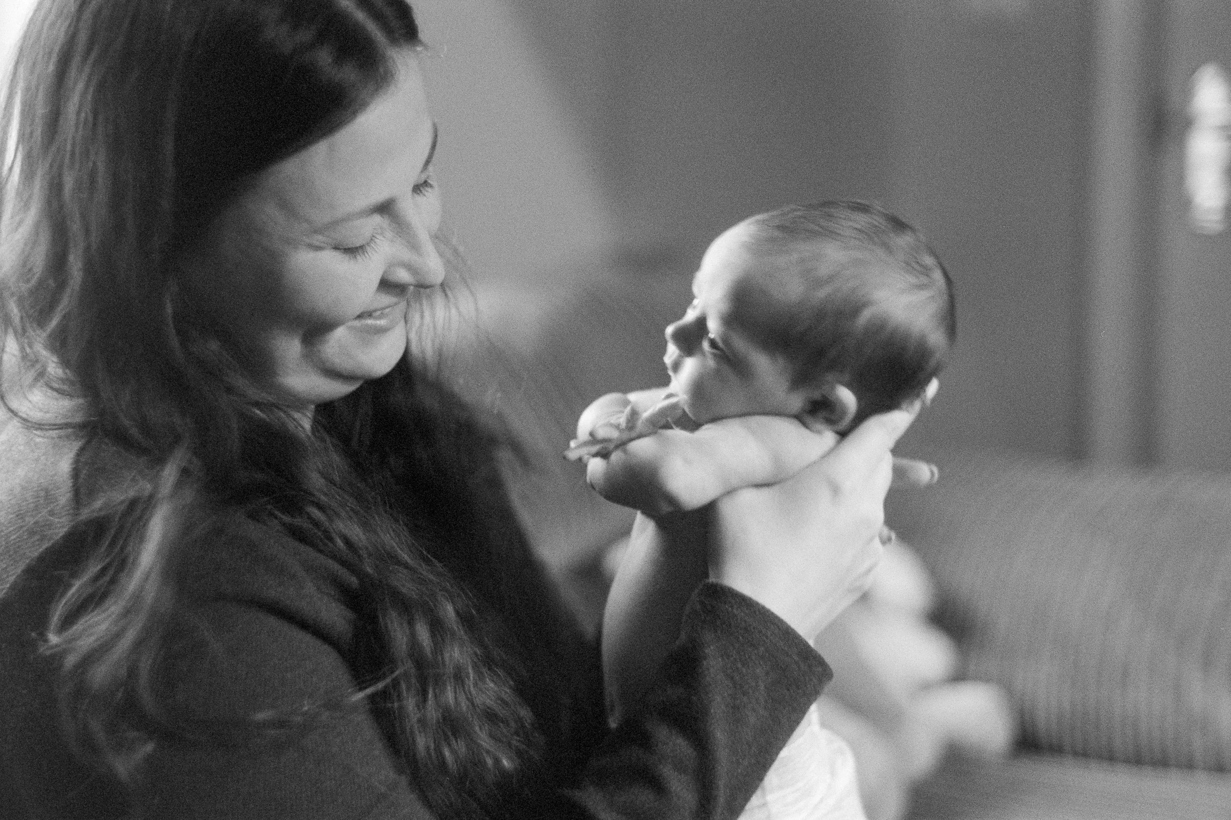 Black and white photograph of a mother holding a baby, used to show the kind of family film images Liquid Light Lab processes and scans with careful handling and strong file quality.