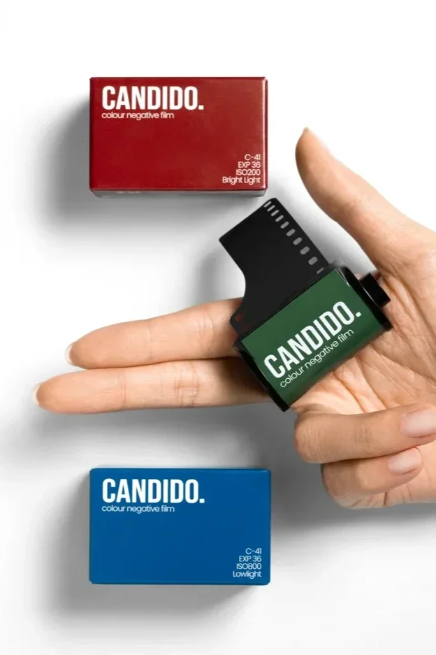 Candido colour negative film boxes and 35mm film held in a hand, showcasing the film brand partnered with Liquid Light Lab.