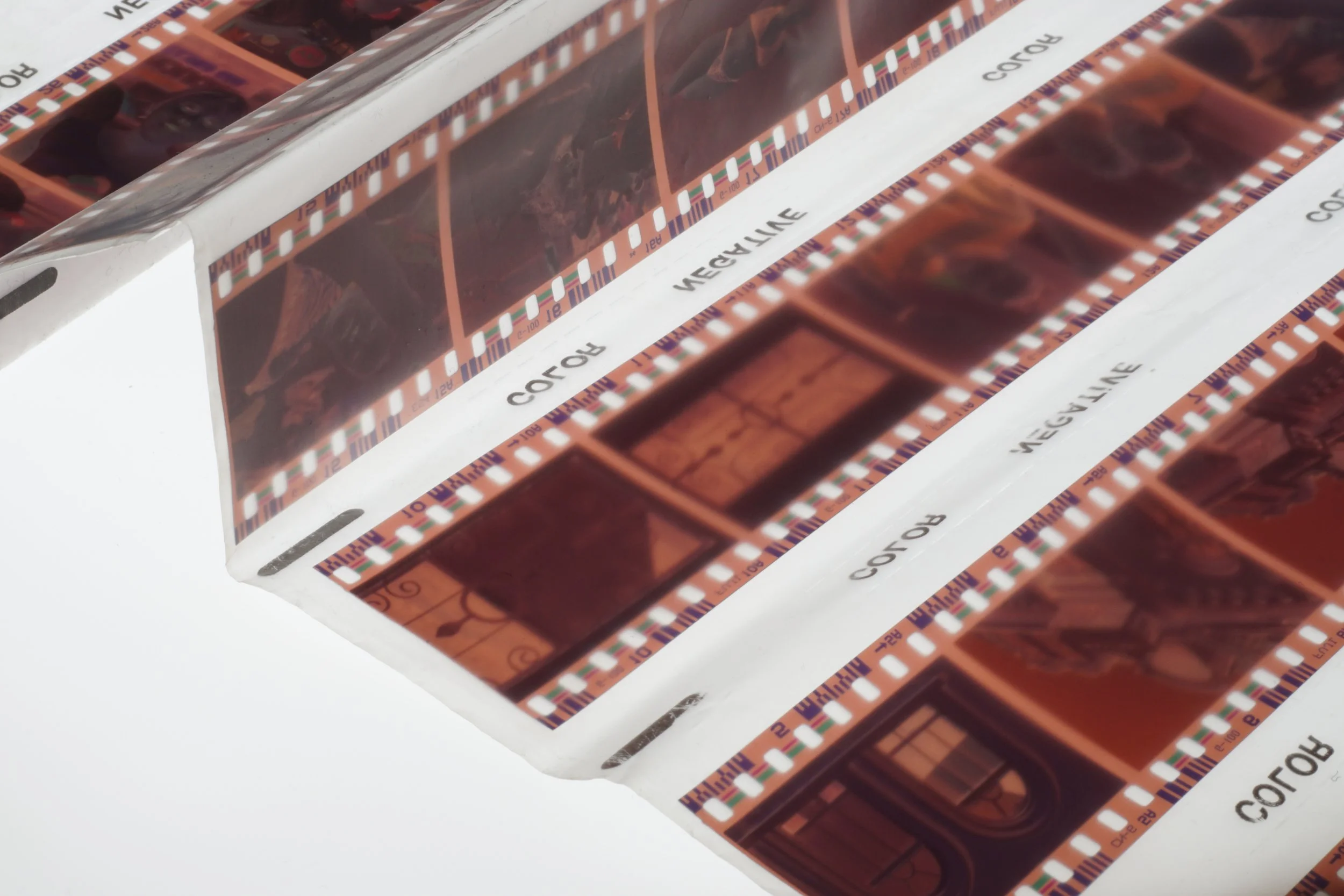 Close view of 35mm colour negative film strips in archival sleeves, shown on Liquid Light Lab’s premium film scanning page.
