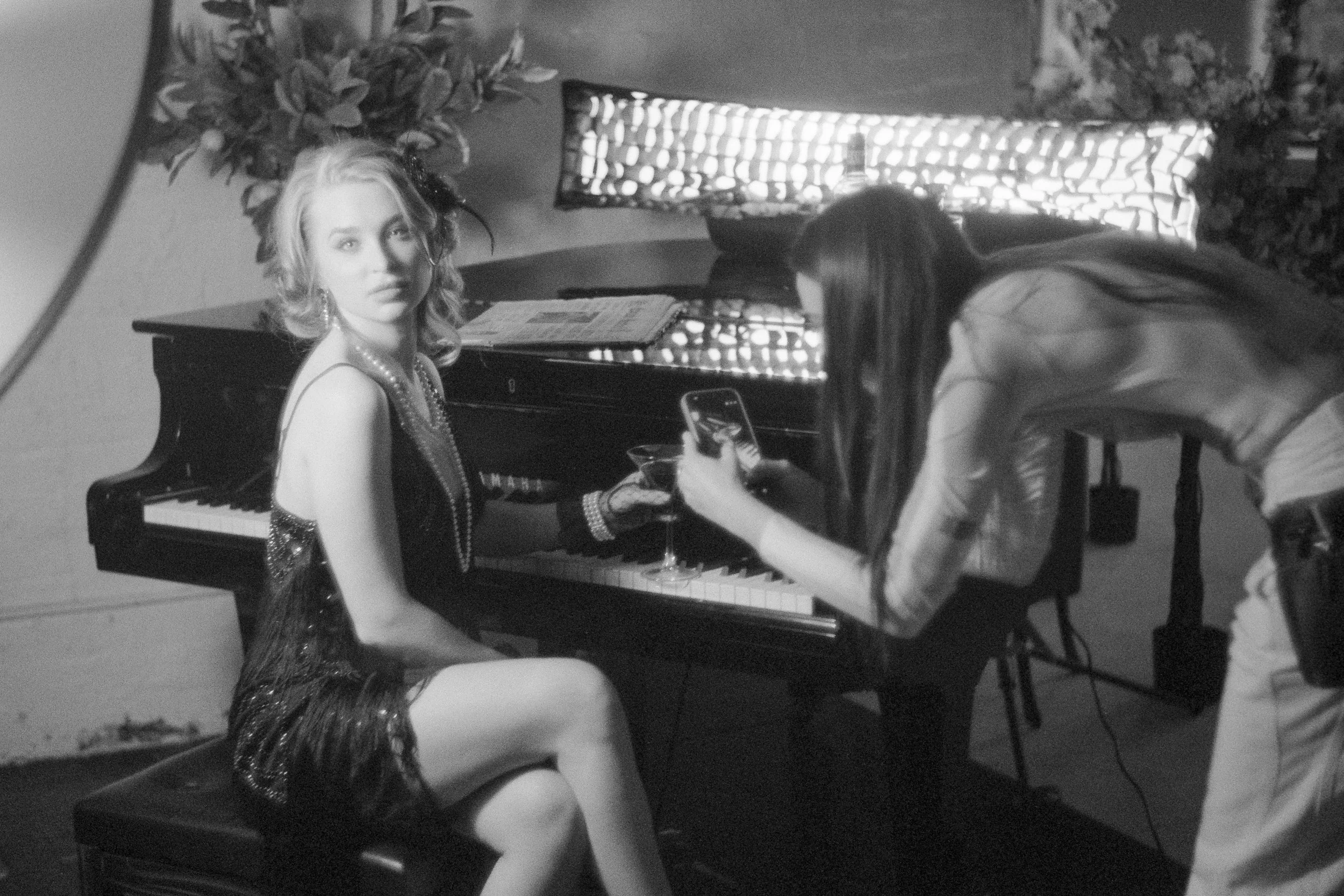 Behind the scenes at the piano during the Candido noir shoot, with a horizontal gridded strip light visible in the background.