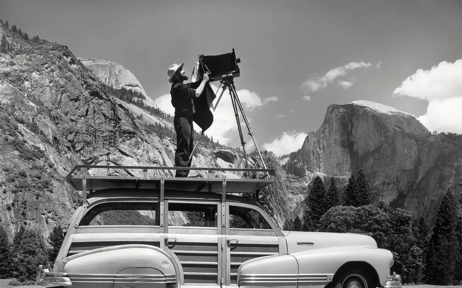 Ansel Adams using his woody wagon as a platform to set up a shoot in Yosemite National Park.