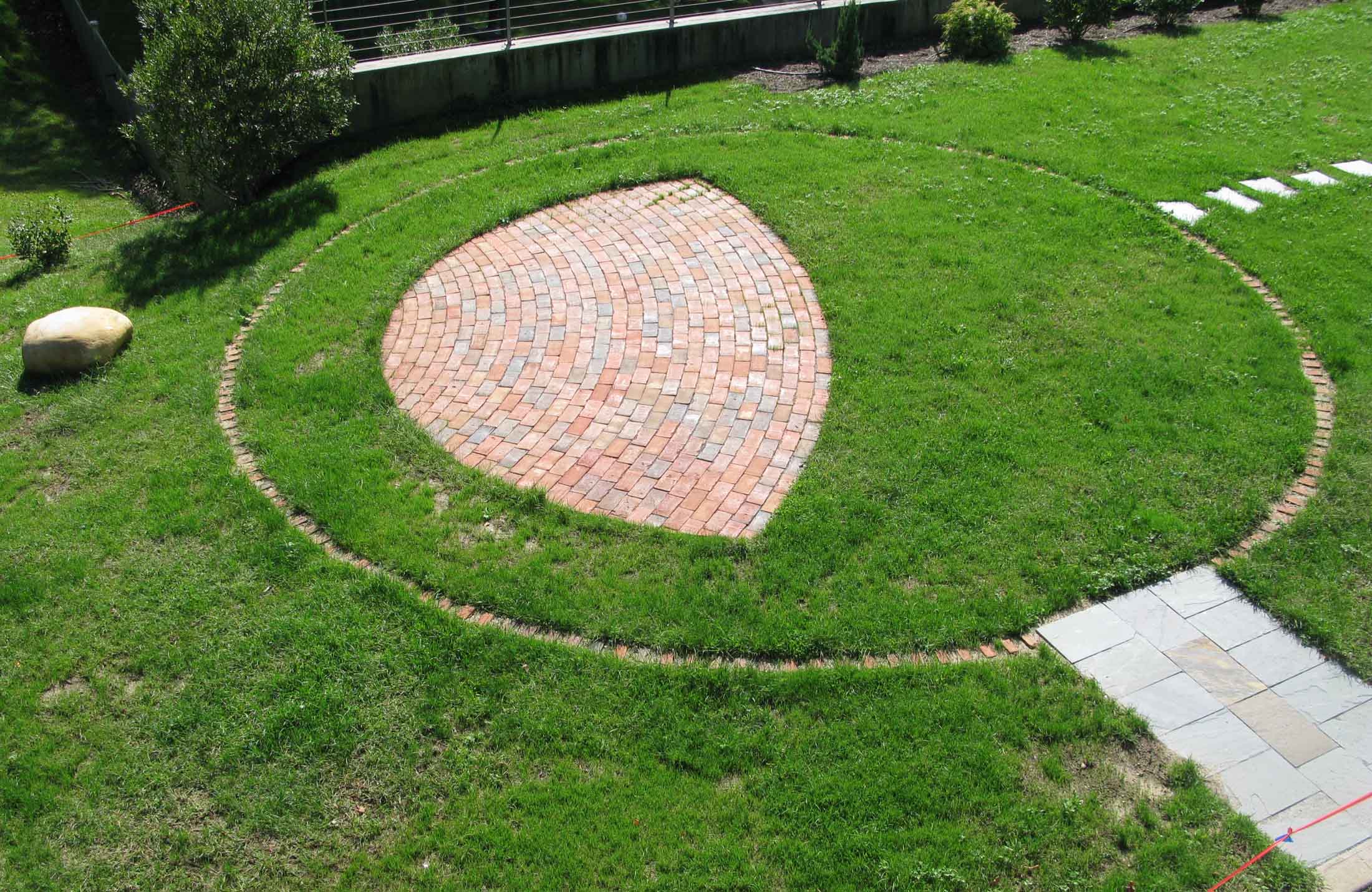  Bricks are inscribed with the names of the Remembered, arrayed in a circle centered on the Memory Stone, a regional glacial anomaly. 