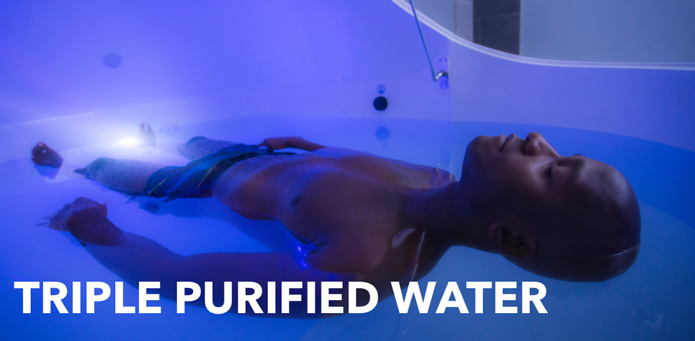 Urban Float | Premier Flotation Therapy Spa | Float Tanks | A man lays on his back with his eyes closed as he is suspended in the water of a floatation therapy pod at Urban Float