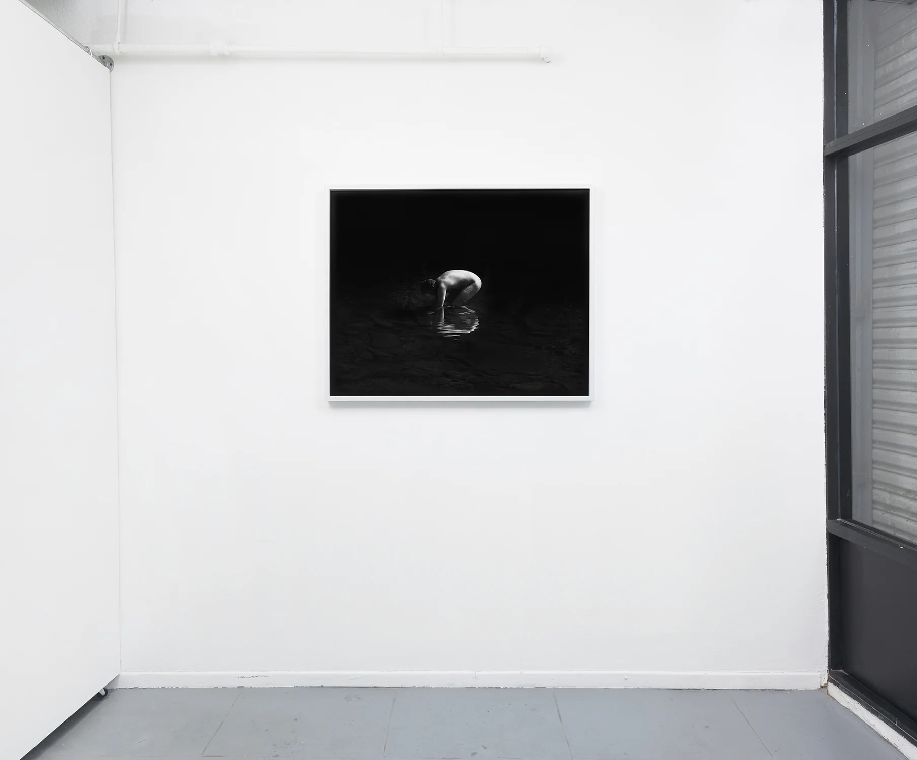 Installation view. .. .if water forgets how to play mirror, 32 x 40, silver gelatin print in painted wood frame, 2018. 