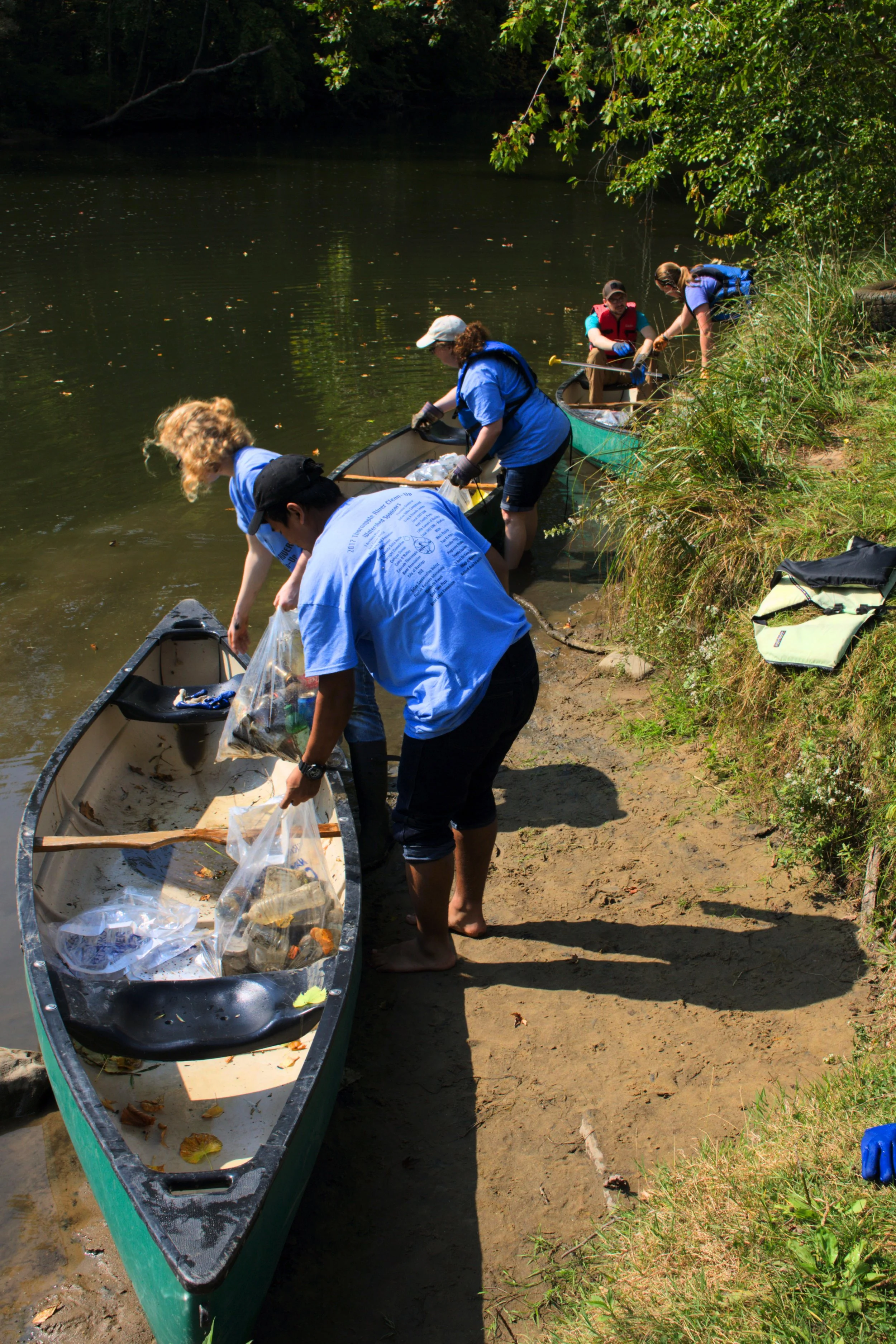 Hana Christoffersen(left) and Khoi Nguyen unload their collection of cast-offs and litter. They both came because of the SWCS, too. The child's life jacket they found(in the grass on the right) was the focus of some bemused concern.