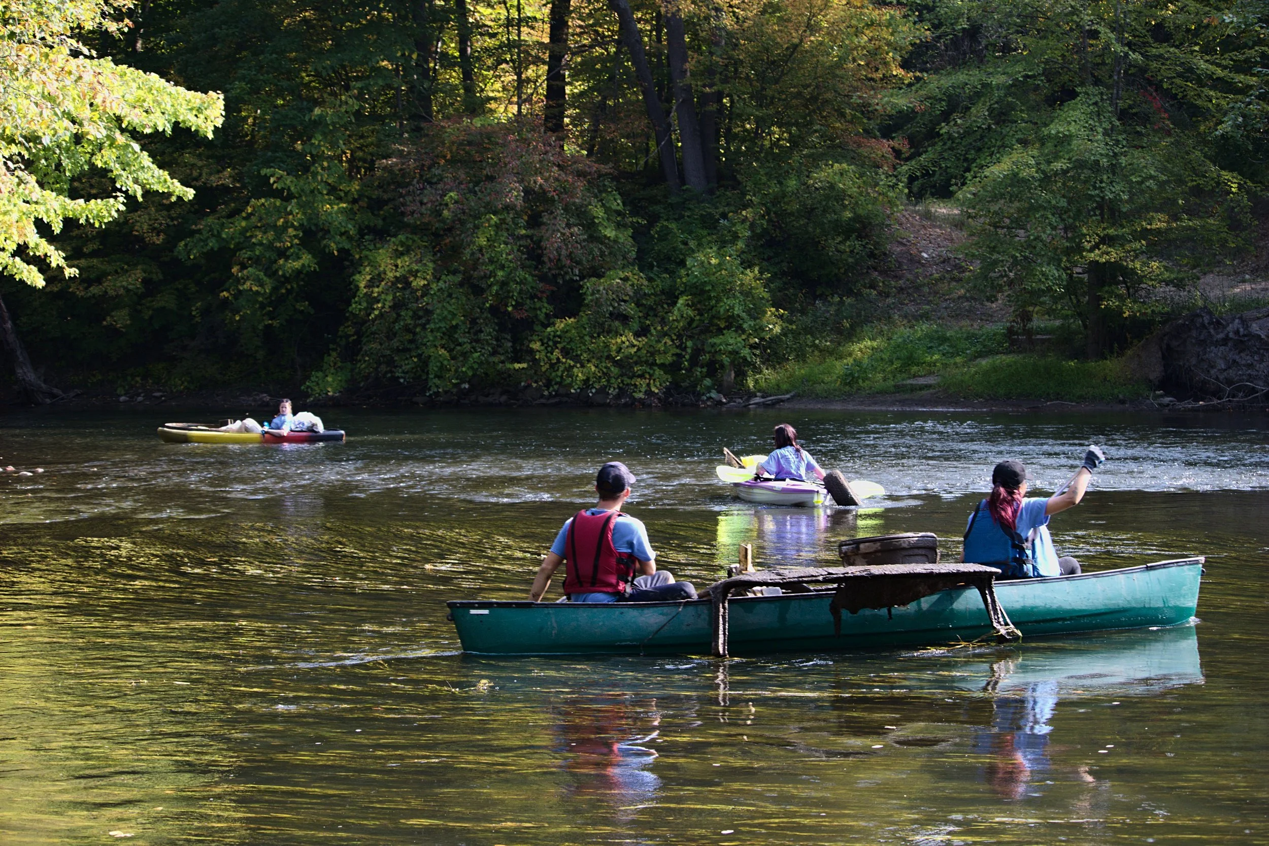 Foera and her sister continue down the river while GVSU freshmen Matthew Silverhart and Avery Duarte push upstream to get around a shallow spot in the river and avoid running aground. Between them on their canoe is the top of a car. Steketee thought perhaps it was part of an old Studebaker .