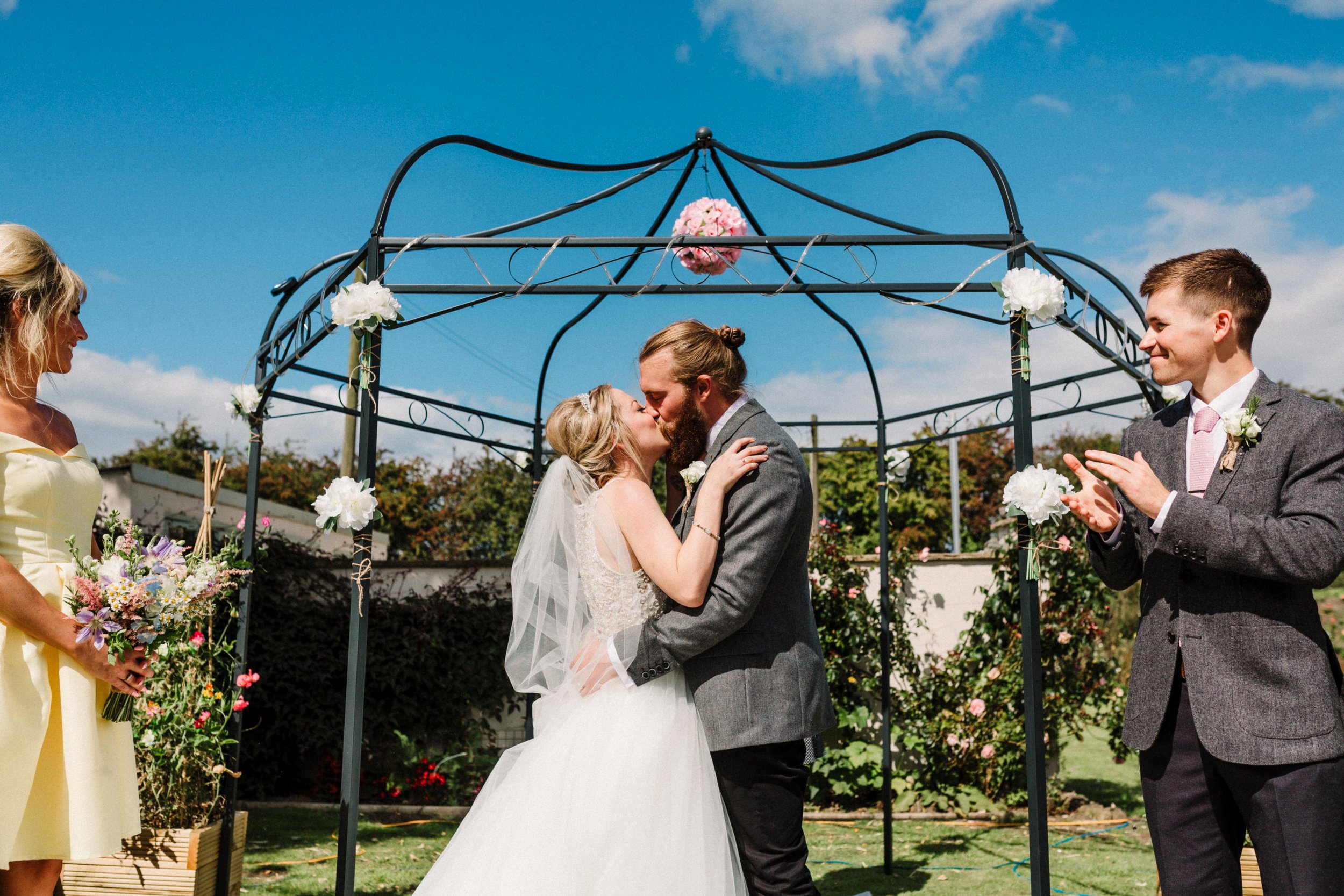 A bride and groom having their first kiss at a Leeds garden wedding