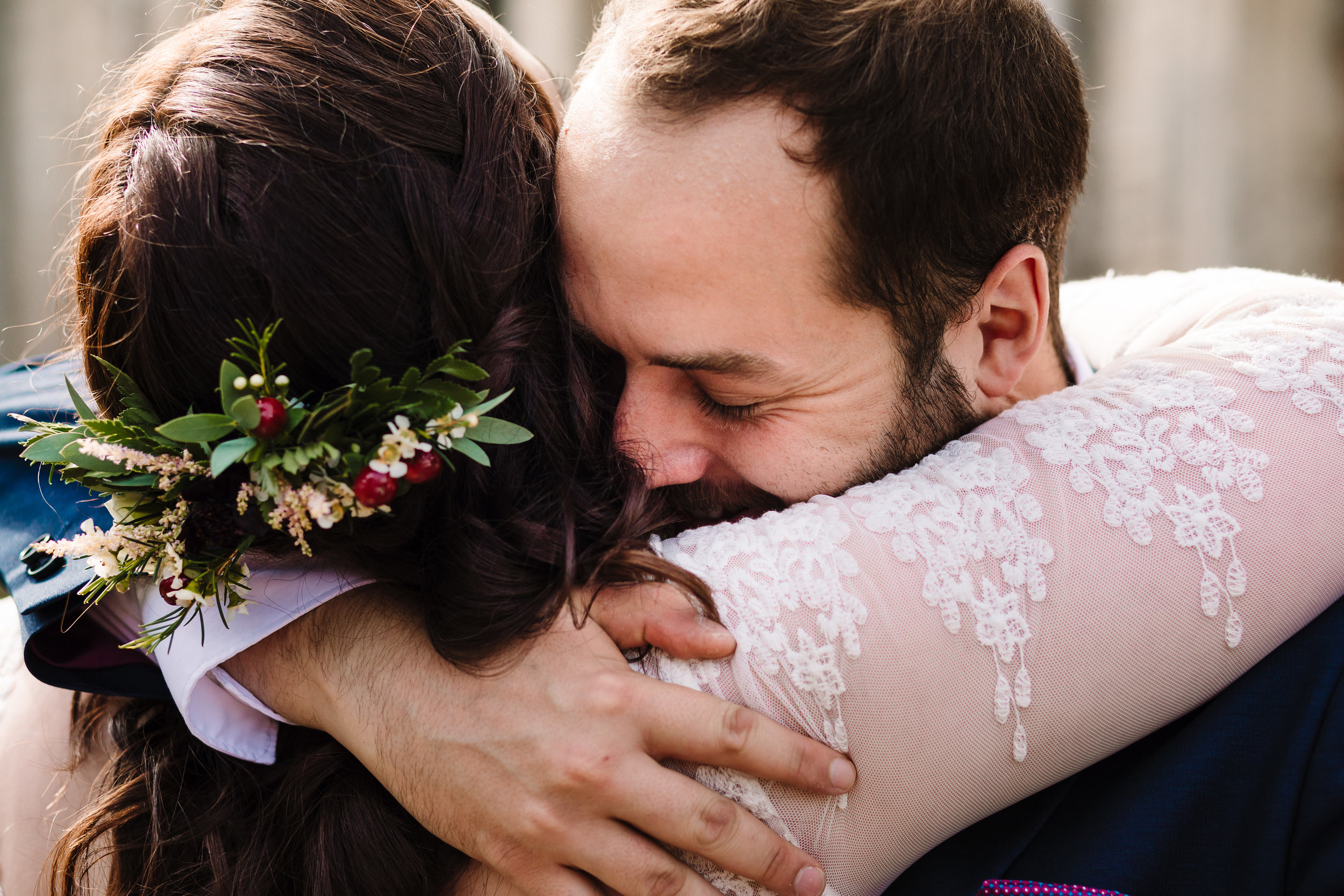 A close up shot of a wedding guest hugging the bride
