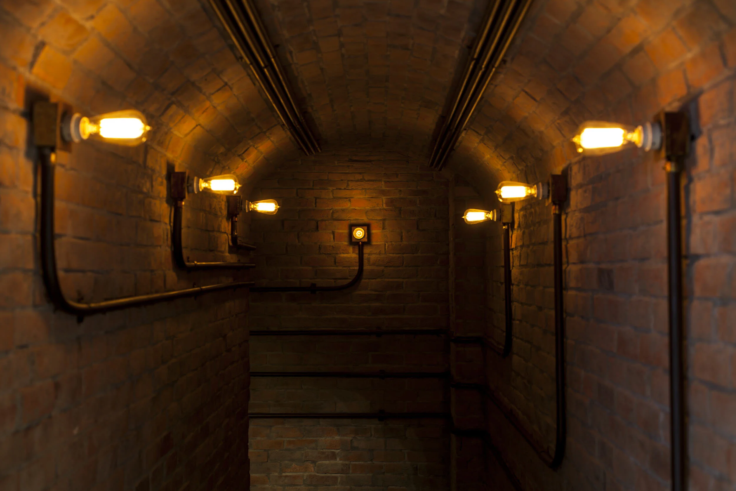  couloir sous terrain en briques éclairé ambiance cave  