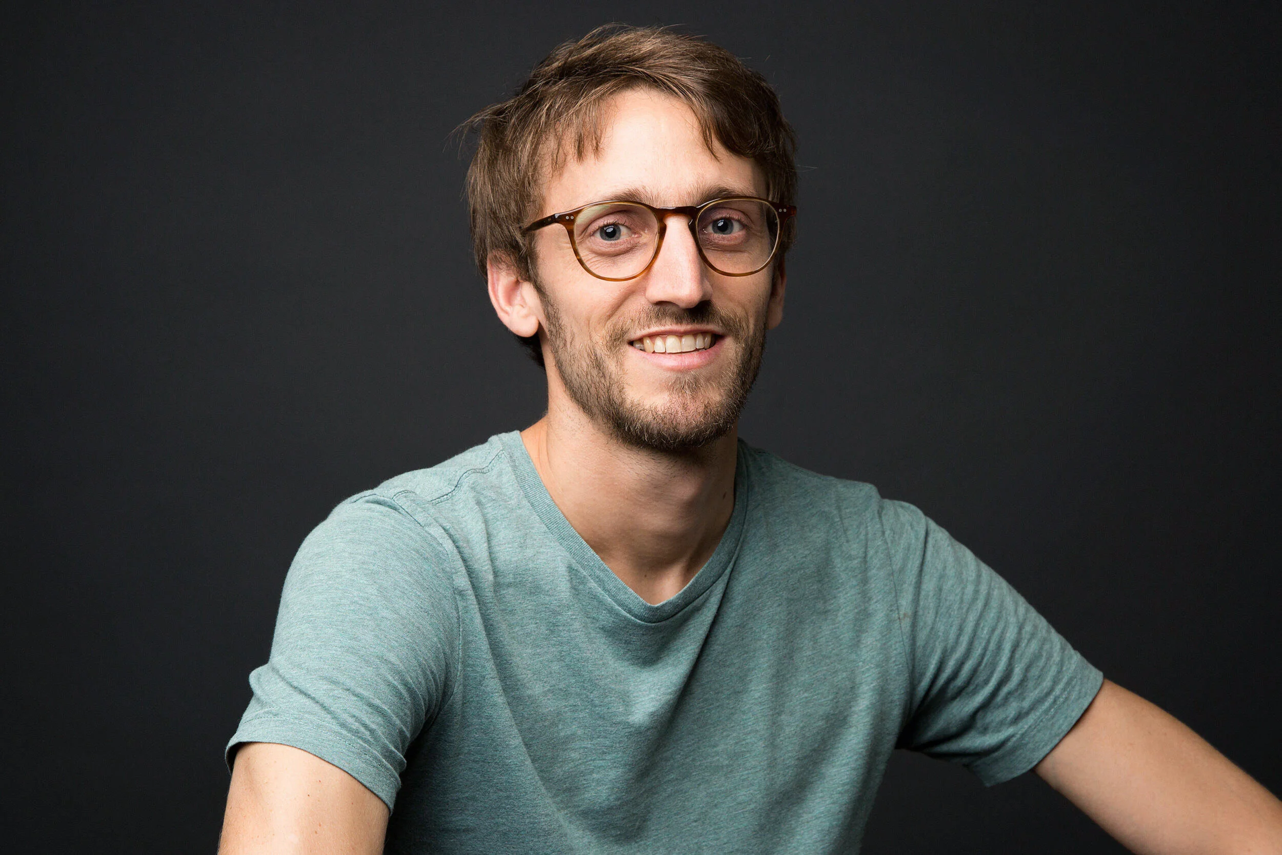  portrait professionnel jeune homme en studio fond sombre 