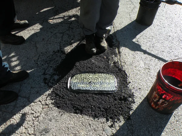 Embedding Philip Matthew’s tile outside The Mud House on Cherokee St. Photo by Laurencia Strauss