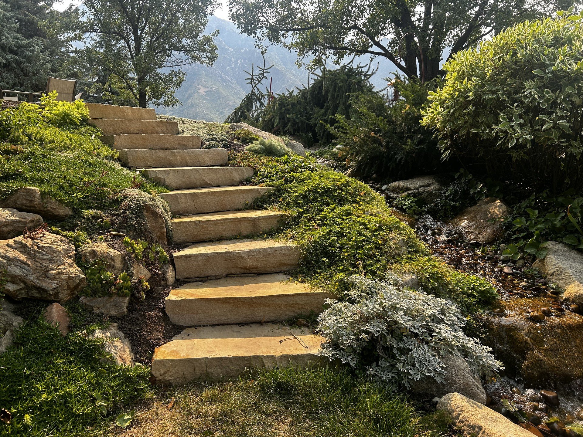 Our talented craftsmen recently installed these granite stone steps and this bubbling brook water feature surrounded by new plants for our client in Sandy, Utah.

#landscapedesign #landscape #stonecraft #stonesteps #granitesteps
#waterfeature #garden