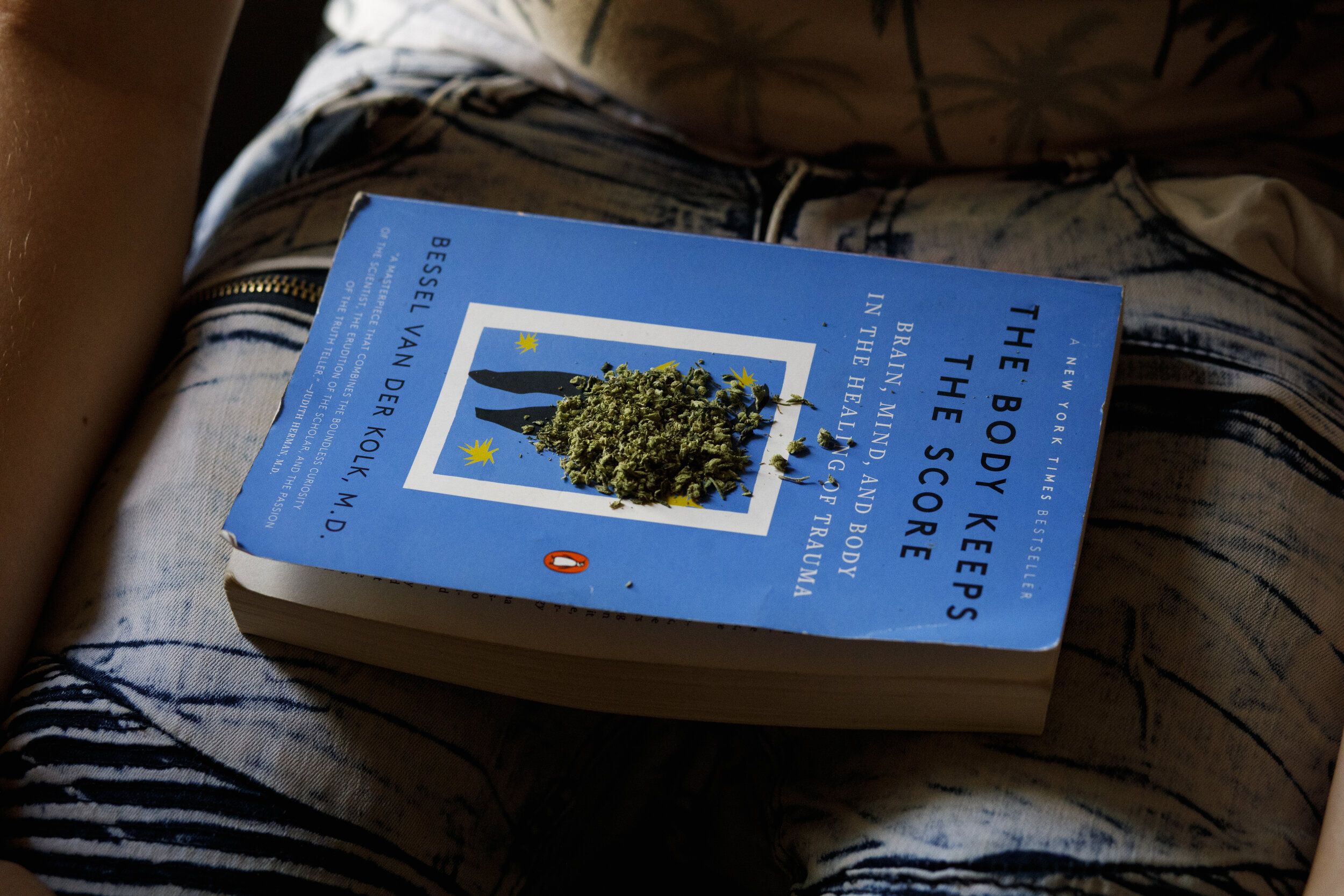  Reuben Kellar rolls a joint on his favorite psychology book, The Body Keeps the Score, in Ben’s living room on March 26, 2021. “The most fascinating thing is brains, like how they work… it's crazy like how minds work like psychology is going to be m