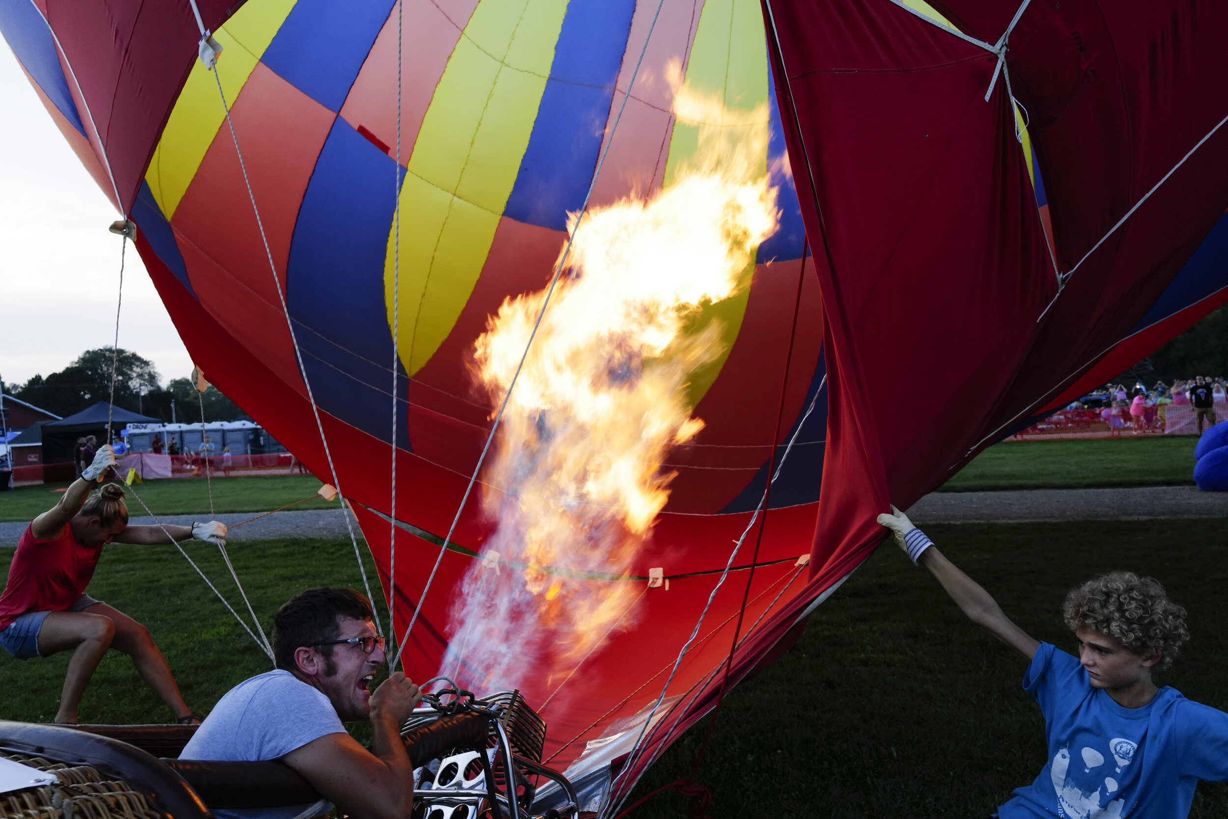  Jeremy Droscha ignites the burners of his balloon “The Flash,” with his son Aubrey and wife Jessica at the Kalamazoo Balloon Fest at Gull Meadow Farms in Richland, Michigan on  August 28, 2021. 