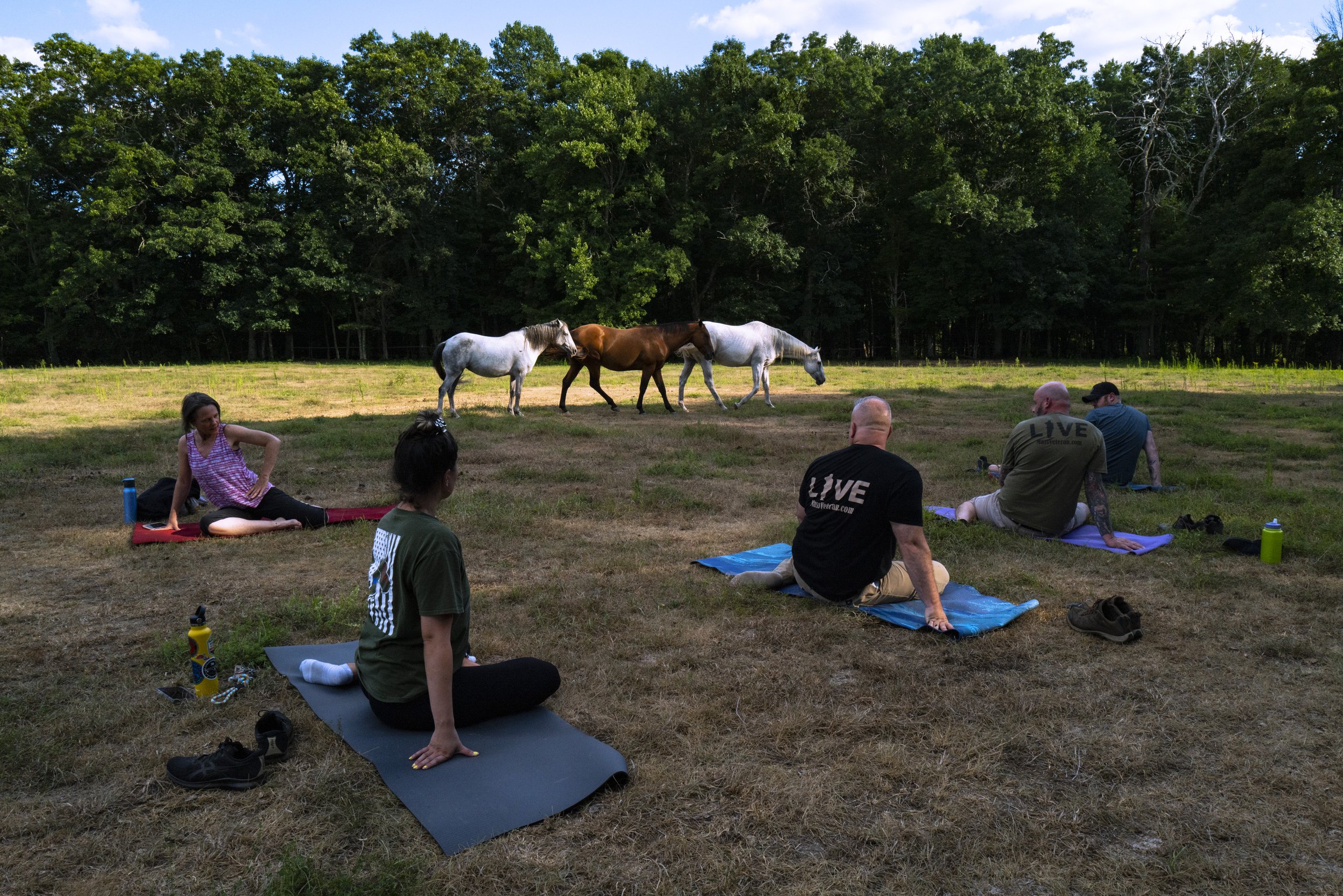  Veterans take part in a yoga class taught by Judy Thapa before they begin working with their horses at Project ComeBack in Holliston, Mass. on August 3, 2022. The classes guide the veterans through meditation and different poses to help with self-he