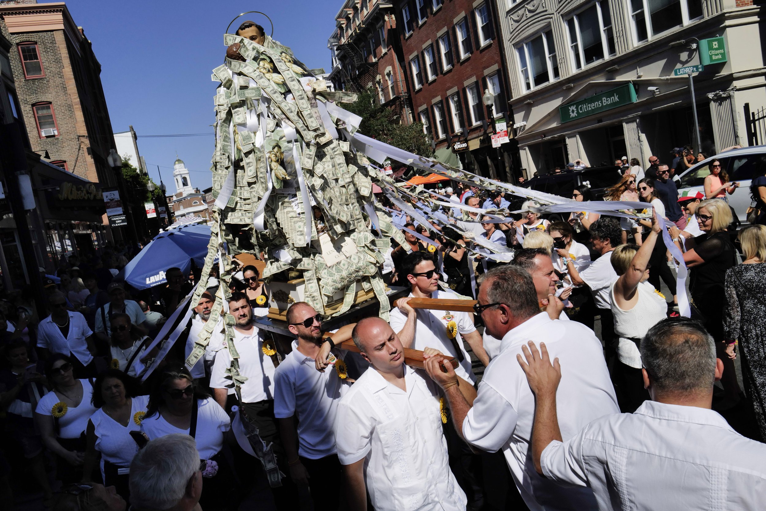  The statue of Saint Anthony is carried through the streets of the North End at St. Anthony's Feast on August 28, 2022. The statue stops by the front doors of homes and businesses where people then pin money to it. 