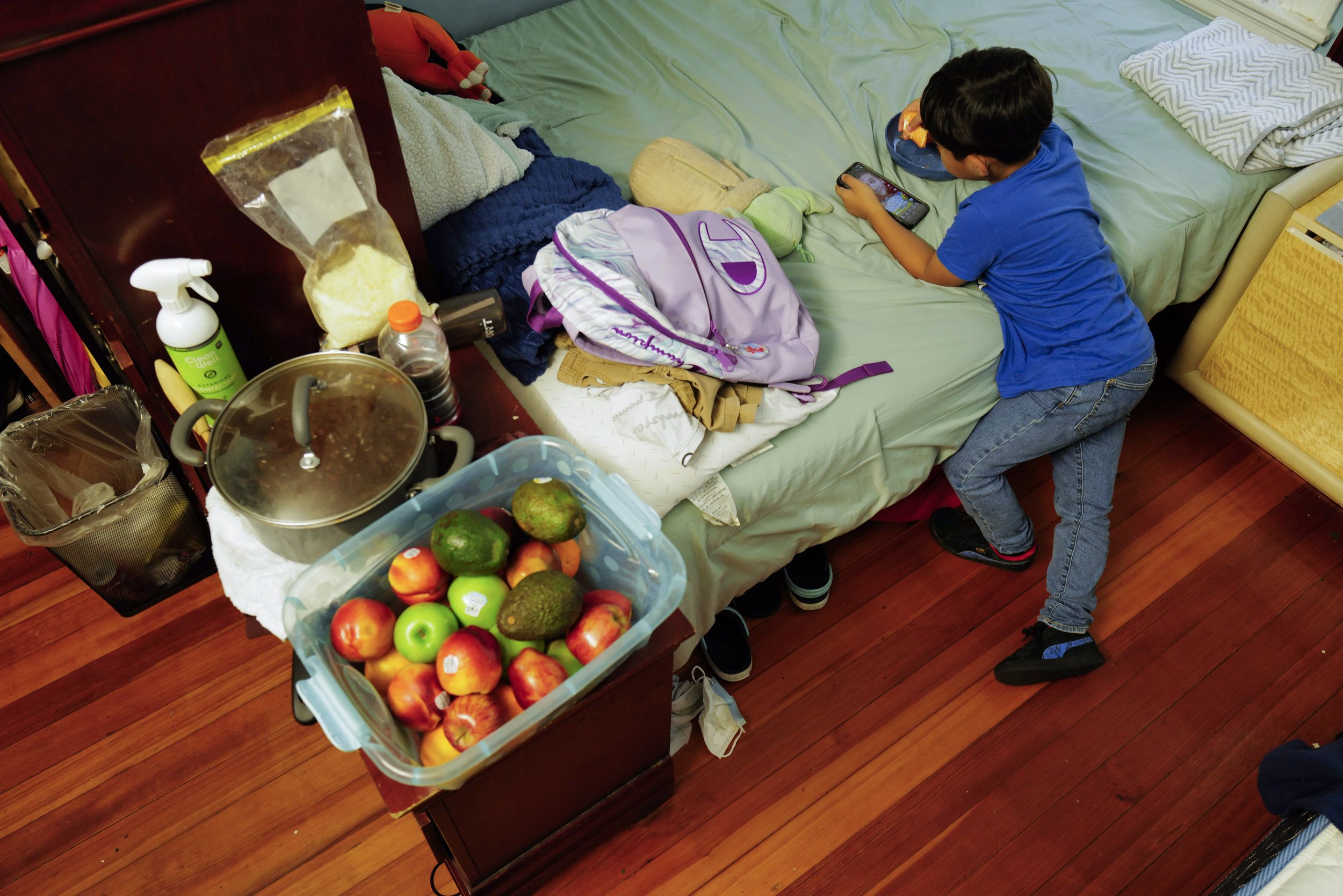  Teresa’s son, Raul Alexis, 6, eats cantaloupe inside the shared room Manuel and Teresa rent in their old residence in Somerville, Mass. on August 31, 2022. Because the room is so small, there is limited space for the family to eat all together. The 