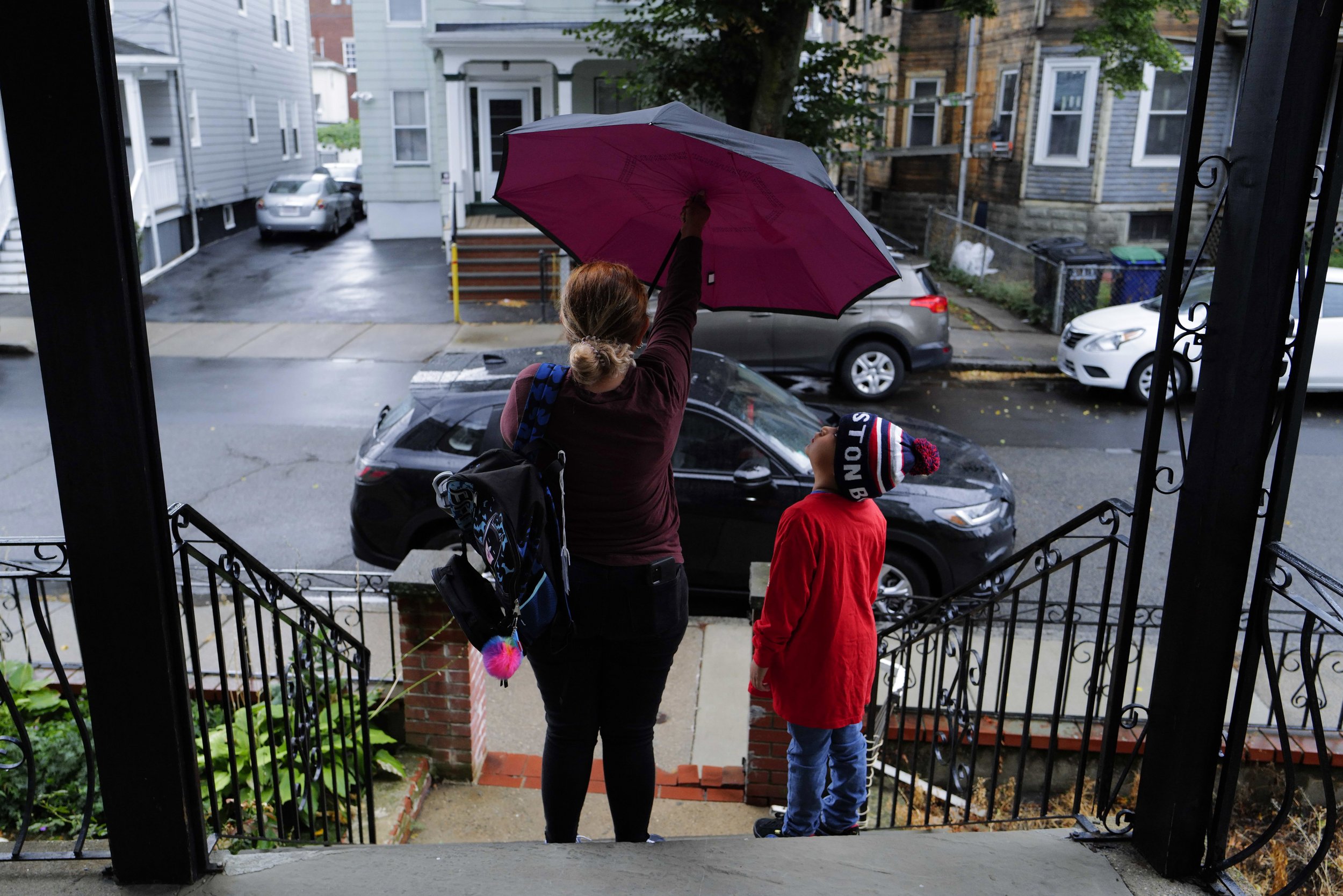  Teresa (left) opens up an umbrella next to her son Raul Alexis, 6, before a rainy walk to school from their old residence in Somerville, Mass. on August 31, 2022. 