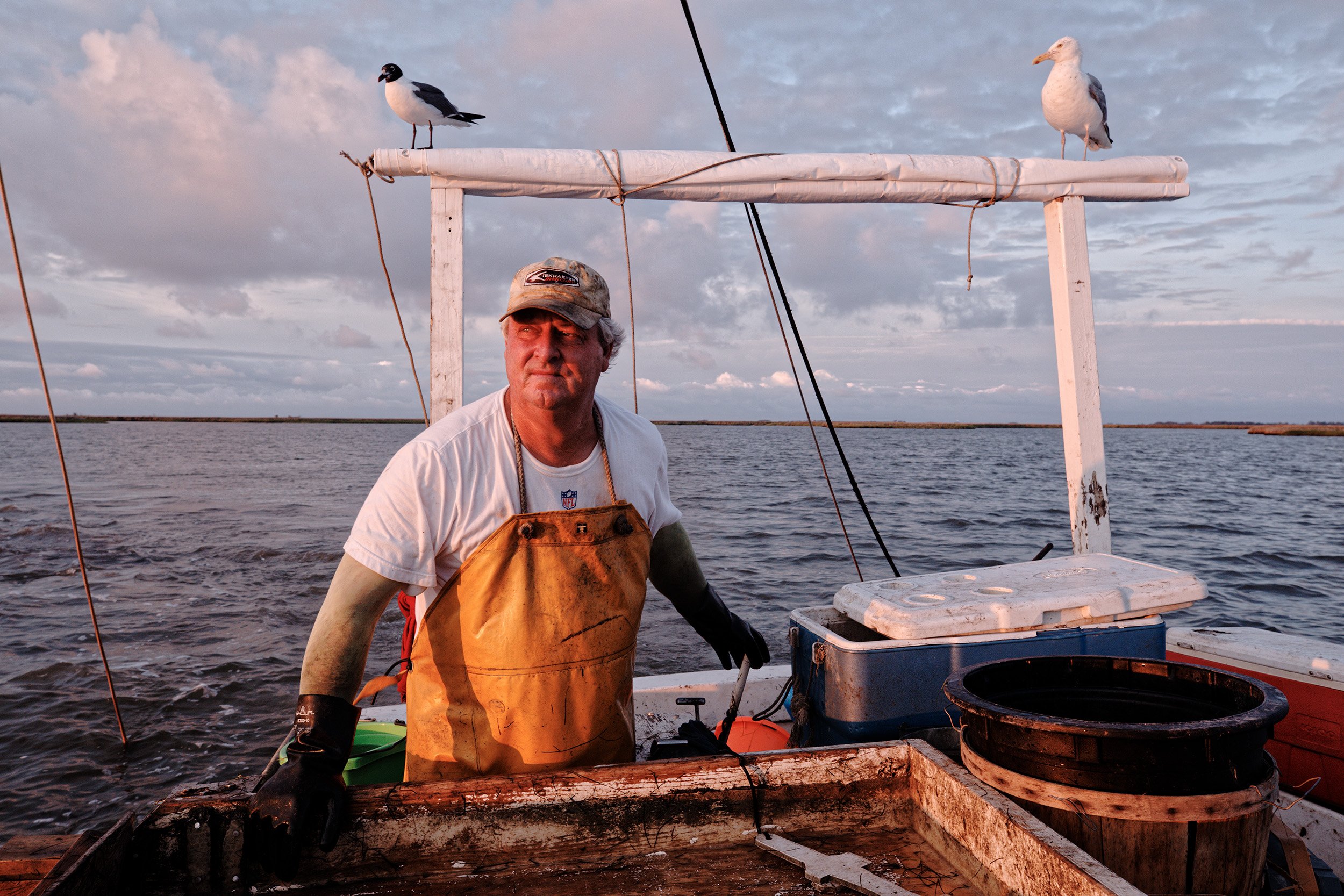  Mark Kitching looks out at his scraper while crabbing at dawn around the waters of Smith Island. Kitching relies on years of first-hand observation and local knowledge to weather the unpredictability of good and bad fishing years. “It’s an industry 