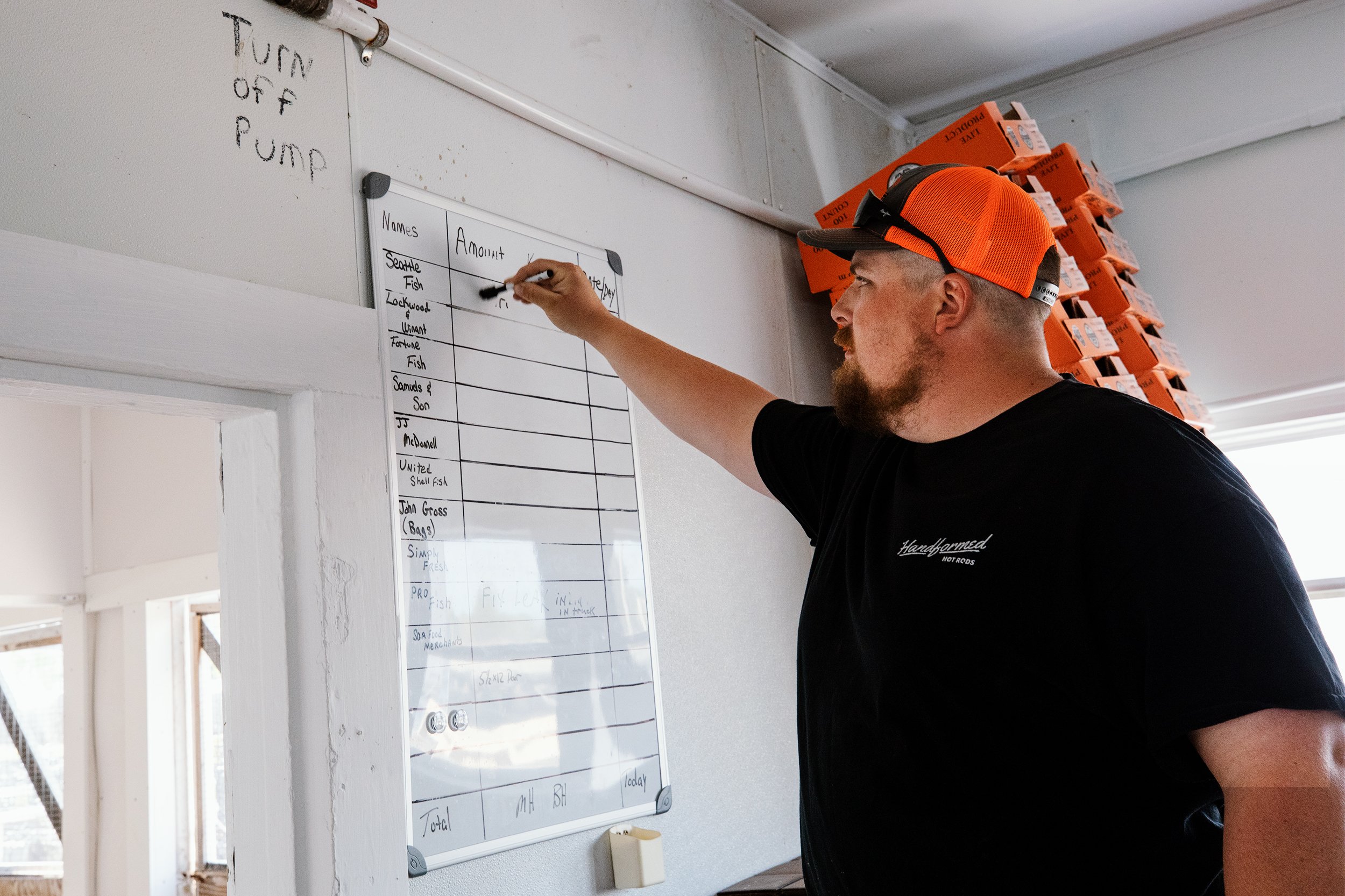  Scott Robinson Jr. erases the whiteboard used to list oyster orders at Madhouse Oysters, an oyster farming company on Hoopers Island, Md. Since Covid-19 struck, restaurant closures and menu reductions have reduced the demand for live oysters and led