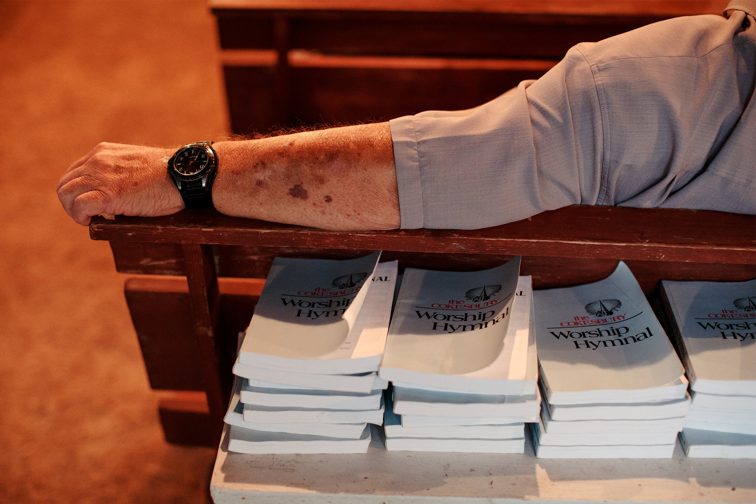  Worship Hymnal books lie behind Captain Terry Laird in the camp meeting ground of Smith Island United Methodist Church. The 134th annual Camp Meeting is a cultural and religious tradition for Smith Islanders that brings nearly all of the community t