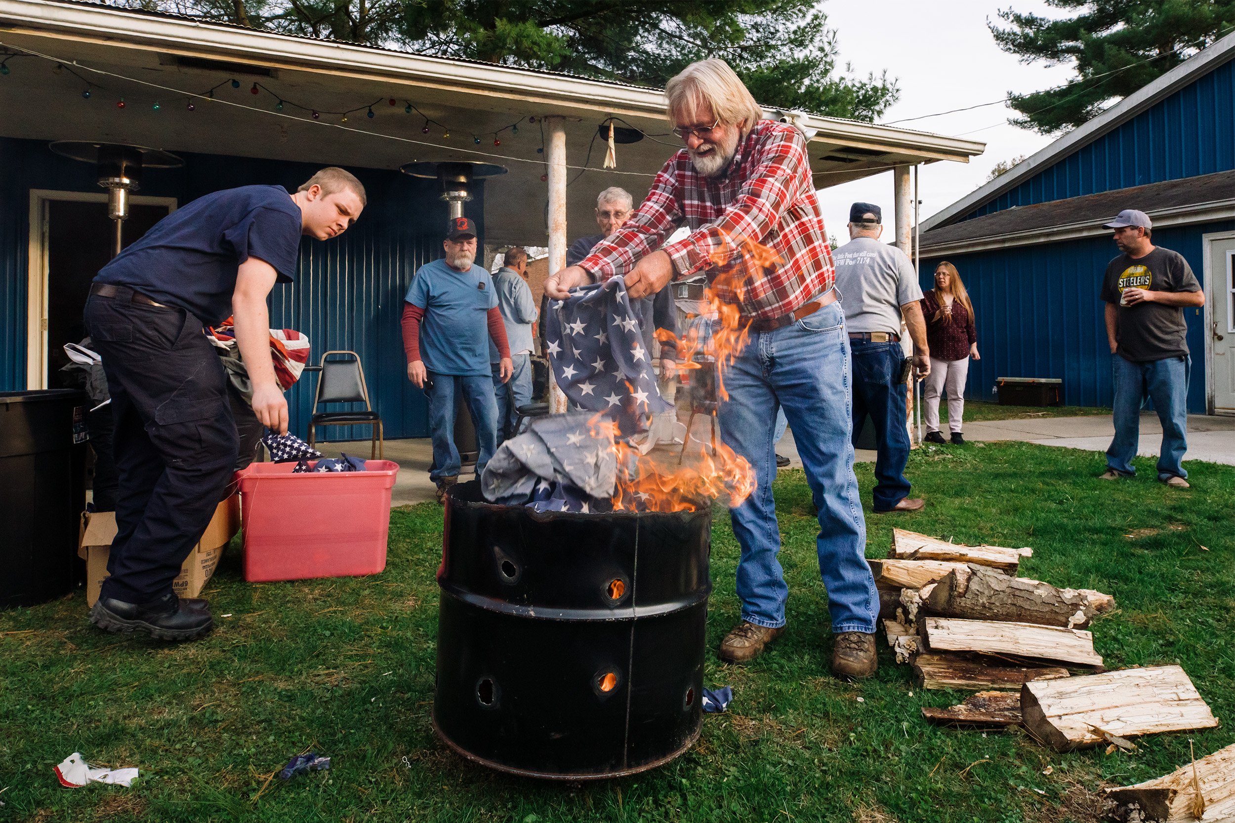  Keith Melling, Athens, Ohio, carries the stars of an American flag to a burning barrel to properly retire it in the backyard of VFW Post 7174 in The Plains, Ohio, on Veterans Day, November 11, 2019. The process requires the stars and stripes to be b