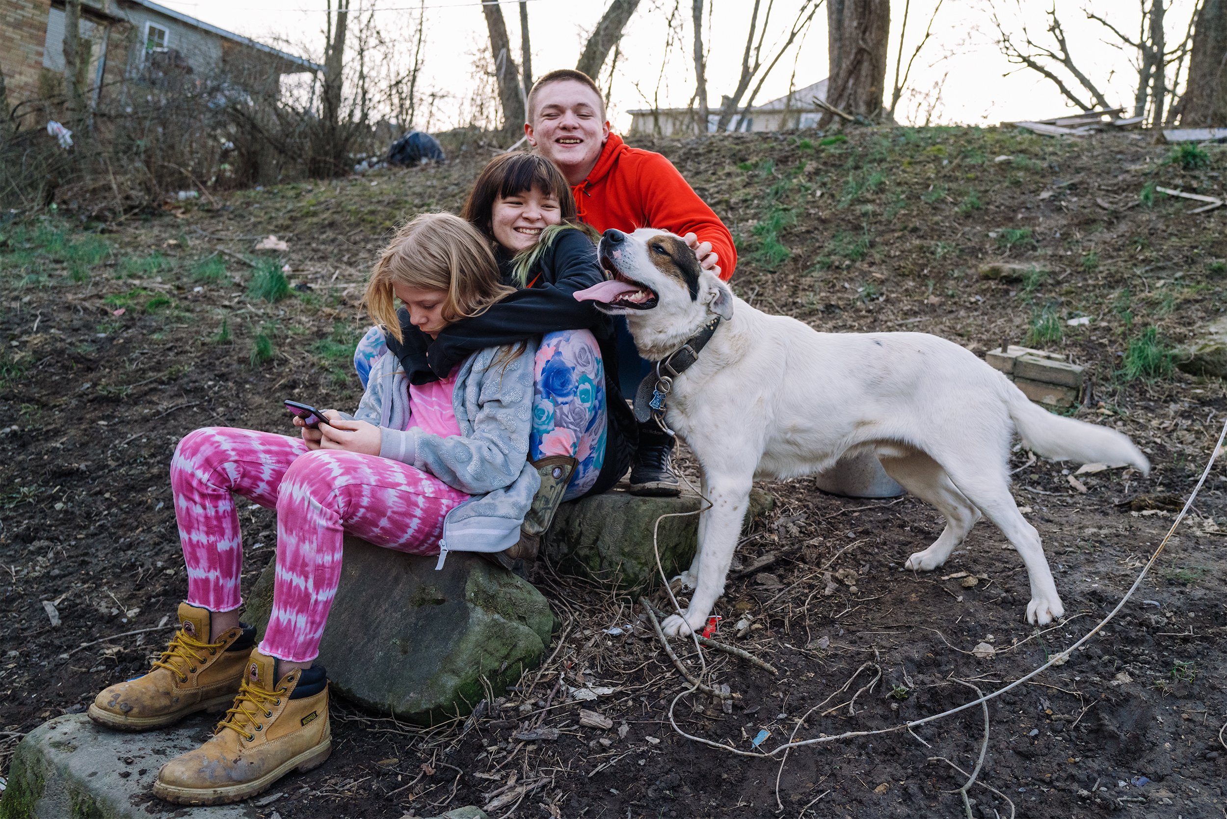  Reuben sits together with his sister Debra (middle), his cousin Carlee (bottom) and his dog Patches on the hill behind Ben's house on March 13, 2021. Having his family torn apart during foster care, Rueben never wants to experience that separation a