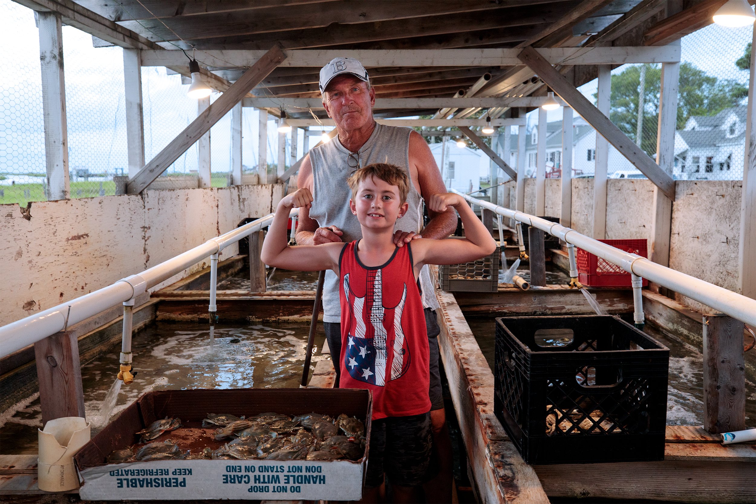  John Tyler, 64, and his grandson, Levi Somers, 8, stand for a portrait in Tyler’s crab shanty on Smith Island. Tyler started working the water at 11 years old, obtained his first boat at 15, and was working on his own at 16. Throughout his years on 