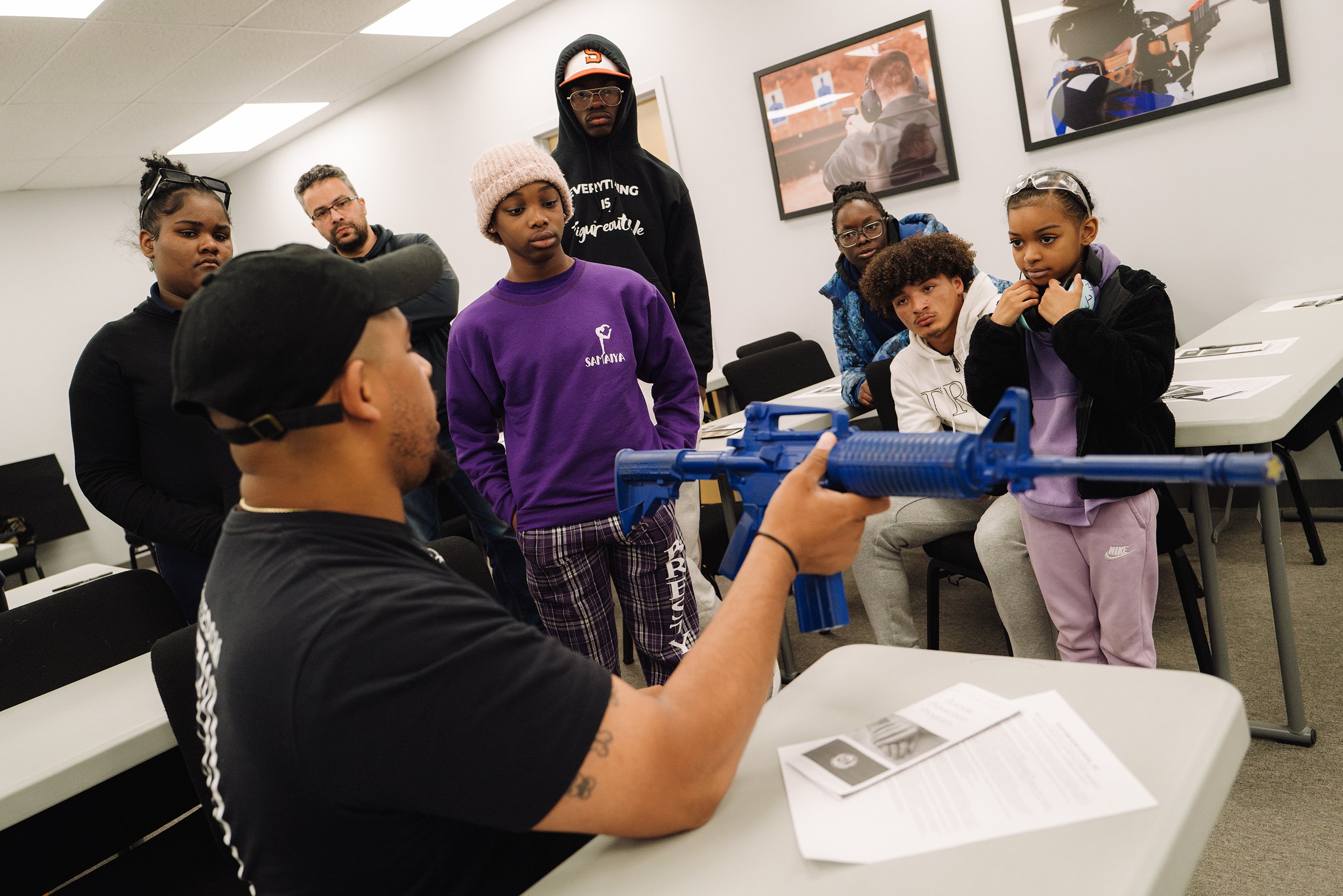  Donkor Minors demonstrates the proper positioning when handling a rifle in the firing range for better accuracy to his youth shooting team at Mass Firearms in Holliston, Mass. Members of the team are accompanied by family members and enjoy a fun str