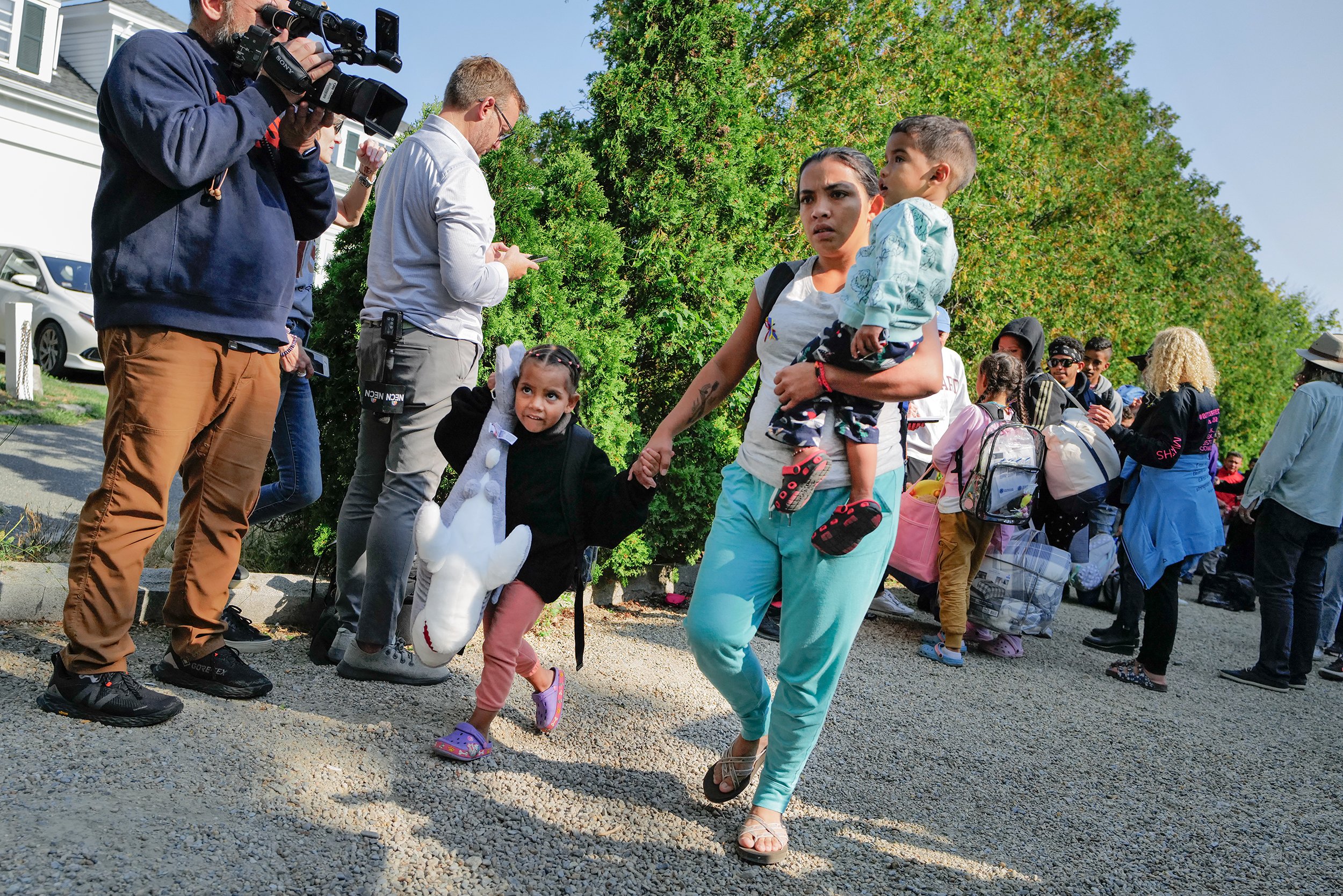  A Venezuelan migrant lead her children onto a bus to the Vineyard Haven ferry terminal outside of St. Andrew's Parish House in Martha’s Vineyard in September 2022. About 50 migrants were sent to the island as part of Florida Gov. Ron DeSantis’ reloc