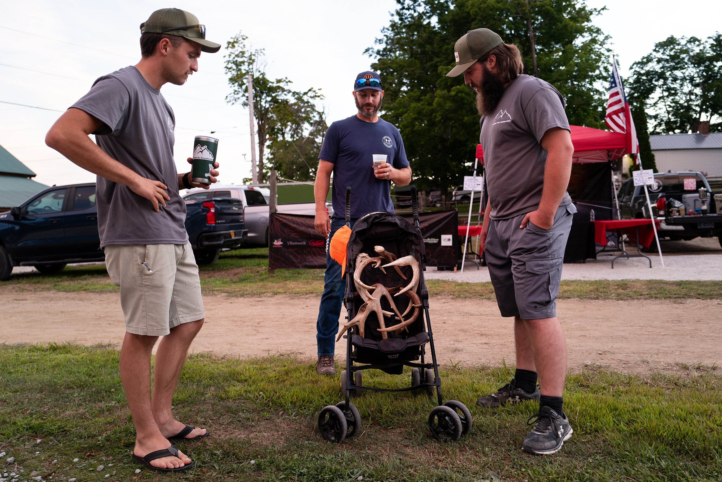  Chad Fletcher (center) shows Ian McKendry (left) and Dawson Daigle a stroller full of deer antlers he shed hunted and brought to Huntstock at Wildwood Farm in Westminster, Mass. on August 12, 2022.  